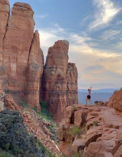 Person Raising Their Arm On a Rock Platform