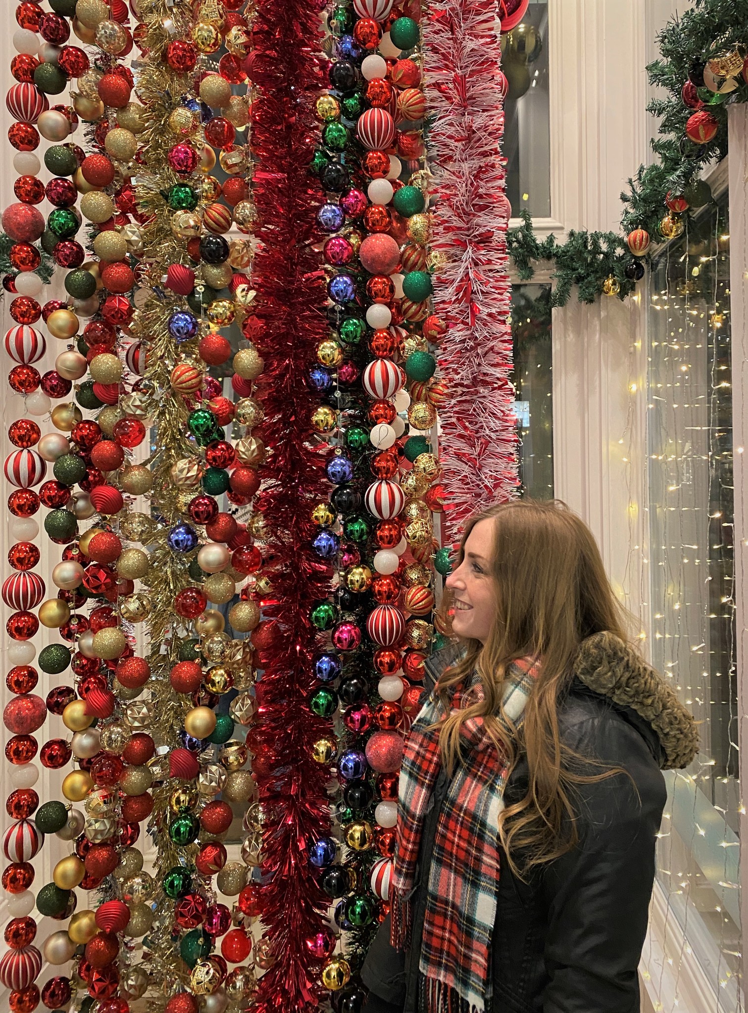 Person Standing in Front of Colorful Ornaments