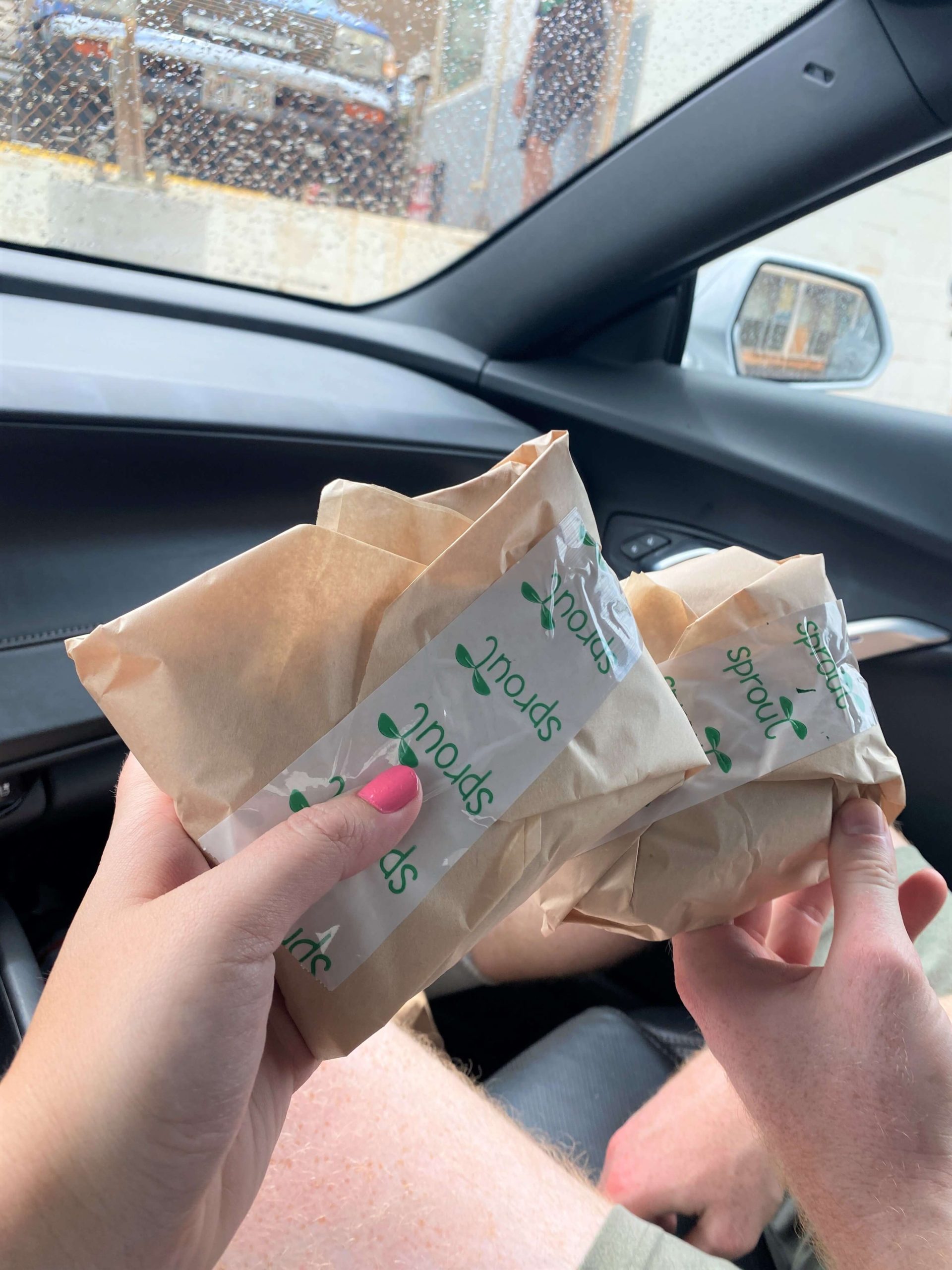 Two People Eat a Sandwich in the Car