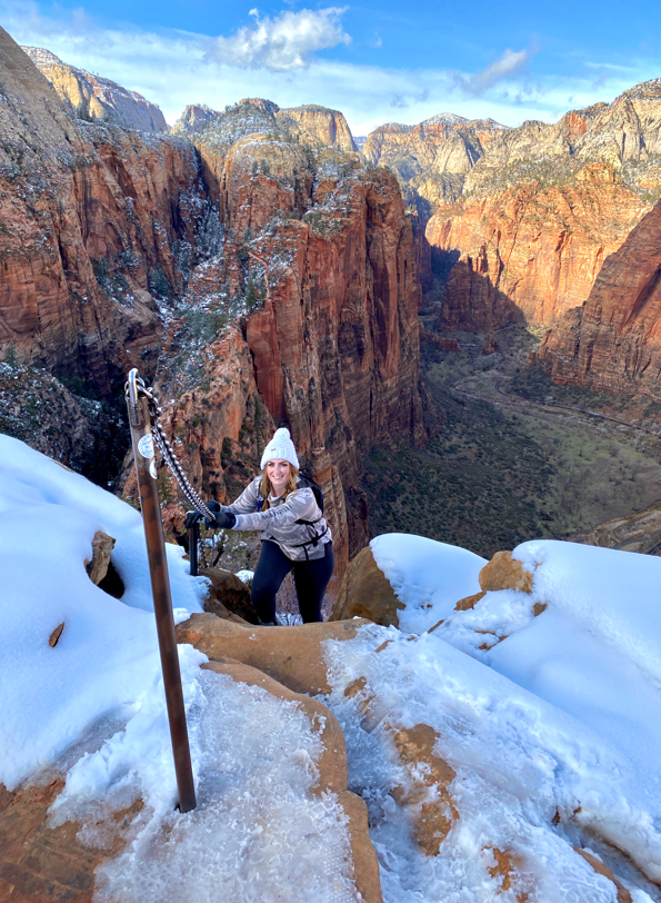 girl climbing up a chained hike in zion