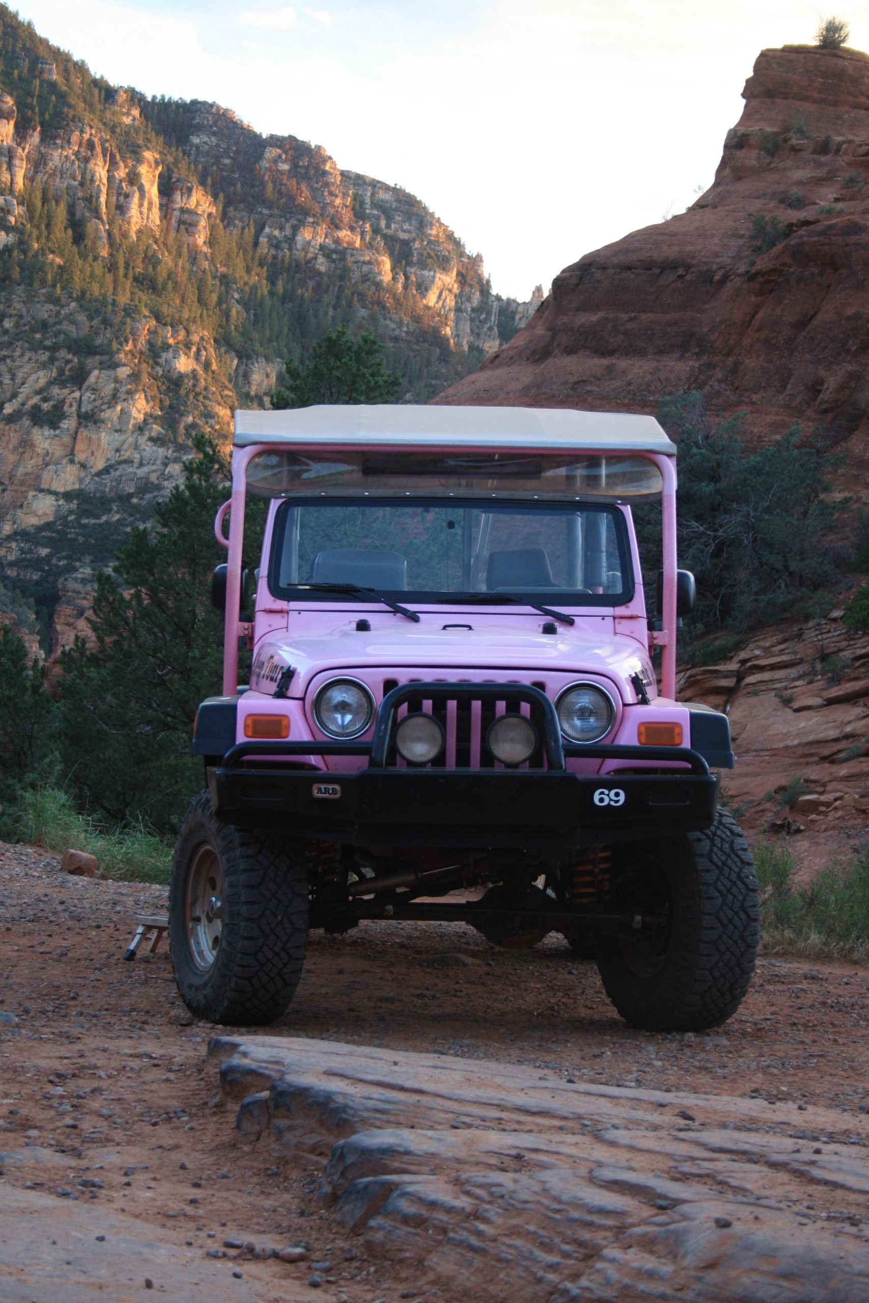 Pink Jeep in Front of Red Rock Landscape at Sunset