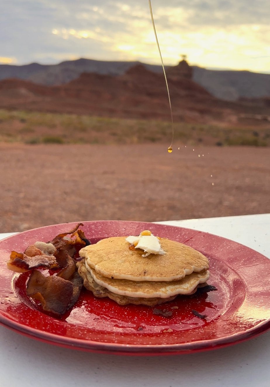 Pancake and Bacon with Butter on a Red Plate with Nature in the Background