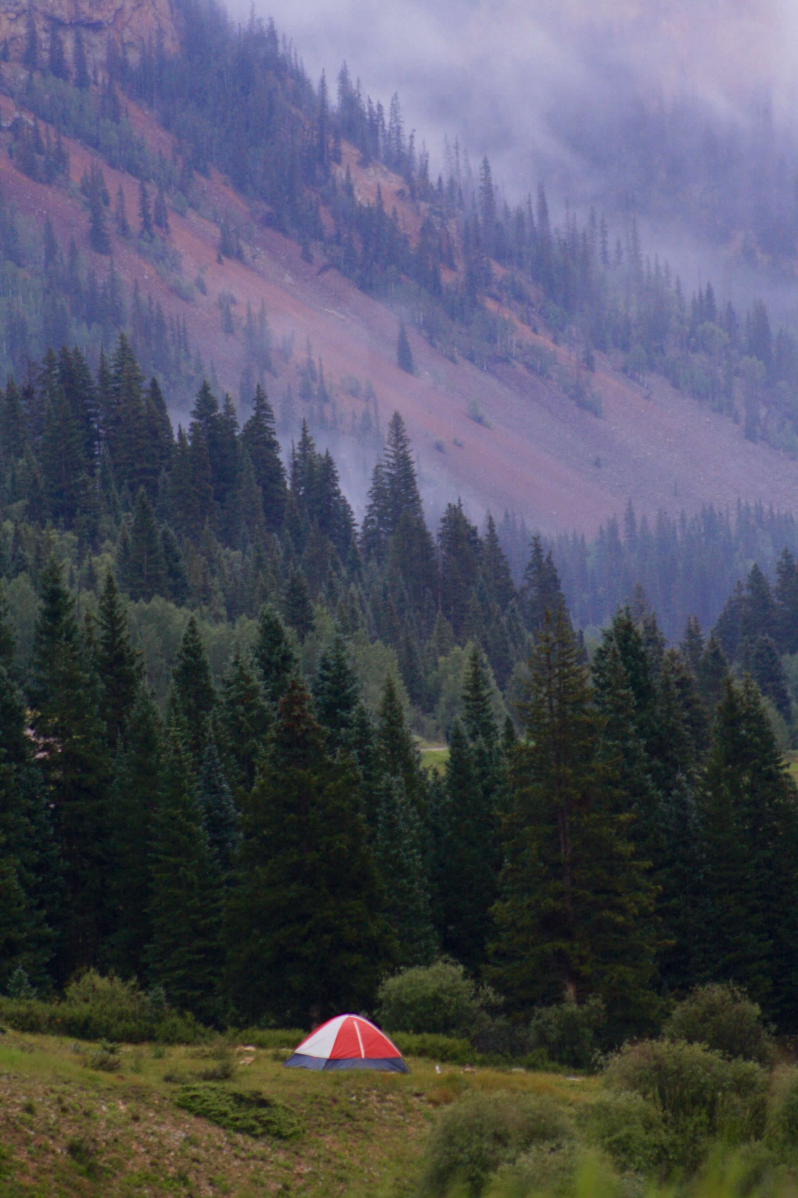 Red and White Tent in the Mountains with Low Lying Clouds