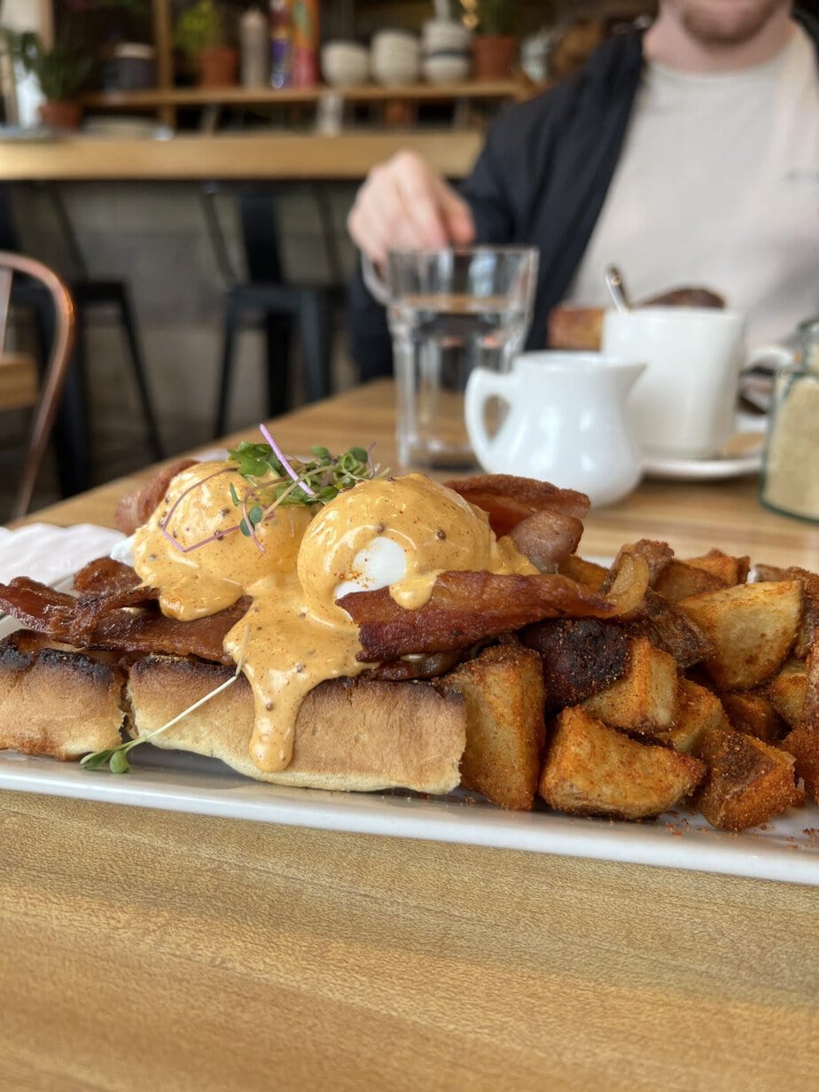 Egg Benedict with Potatoes on top of a Wood table