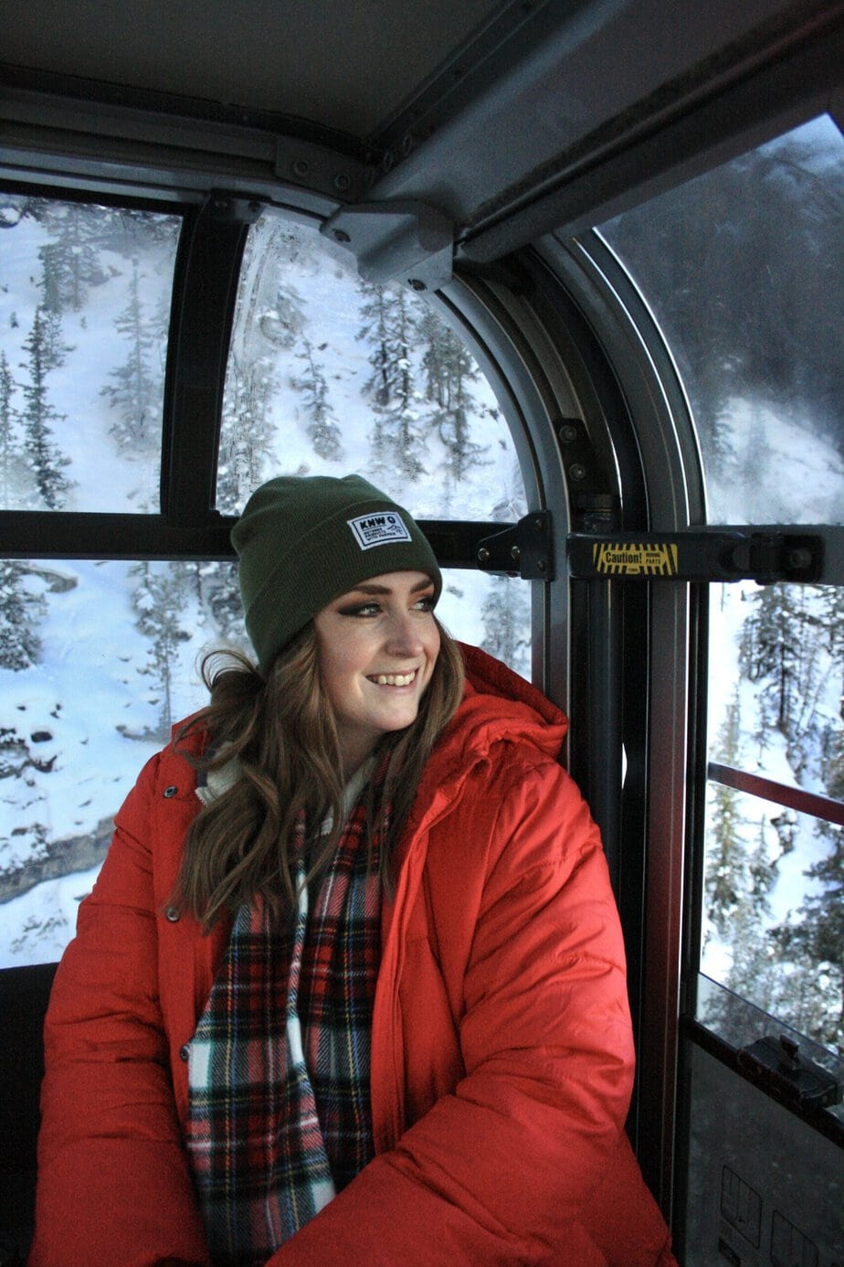 Girl in a Red Coat on a Gondola Looking Outward and Smiling