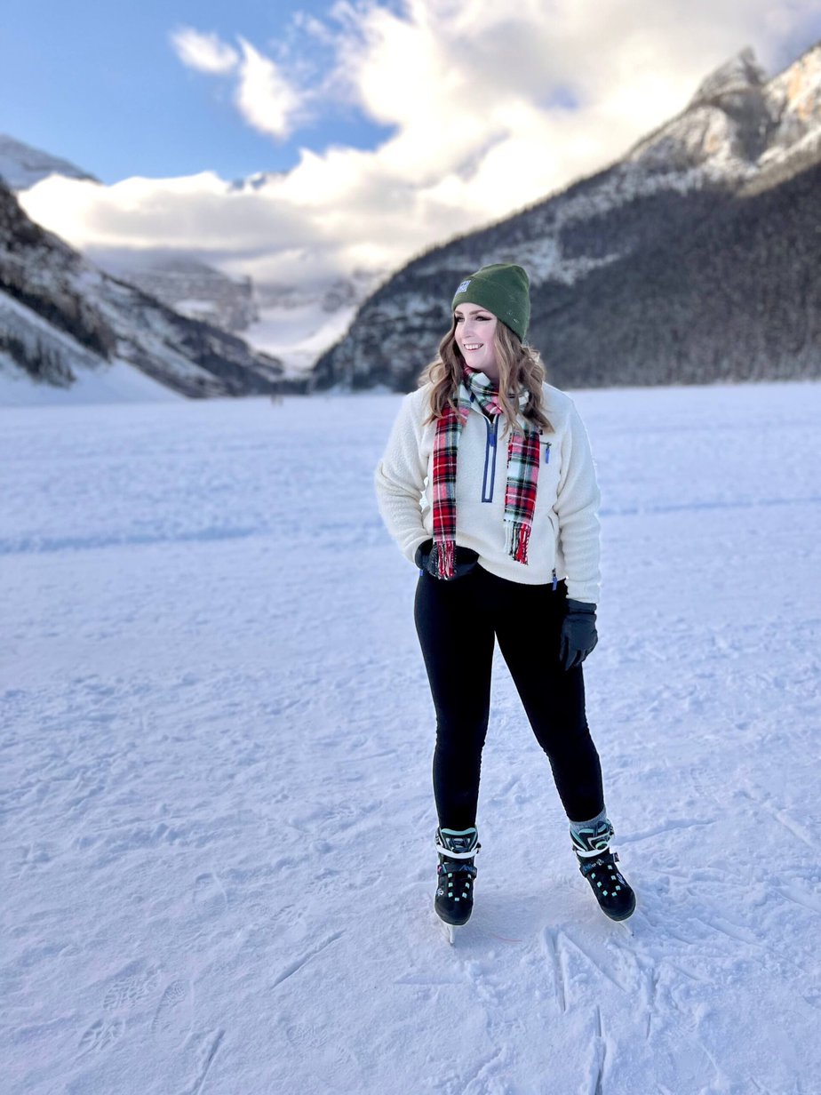 Girl Wearing White Standing on a Frozen Lake in the Mountains