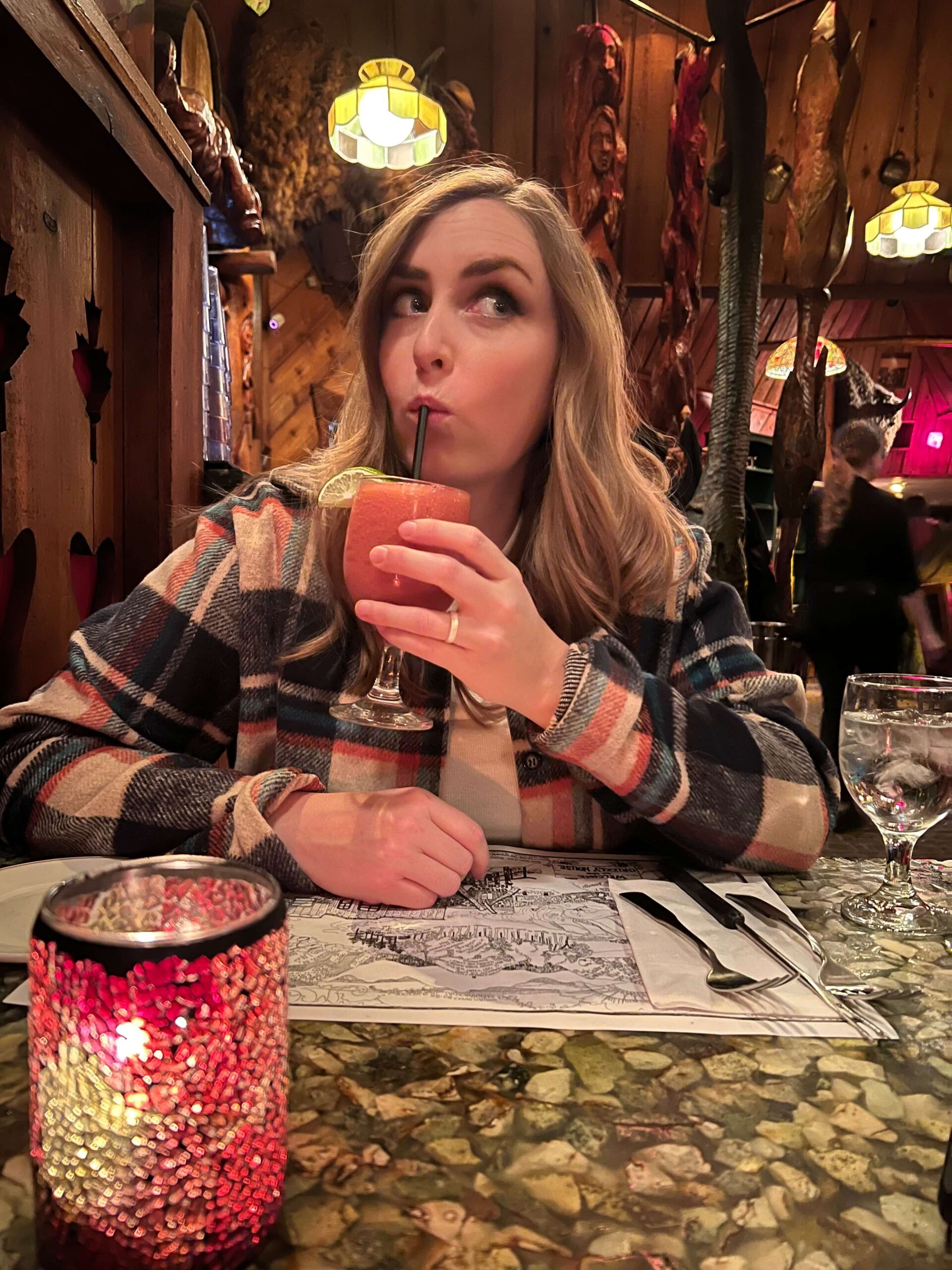 Girl Sipping on a Pink Frozen Drink in a Restaurant