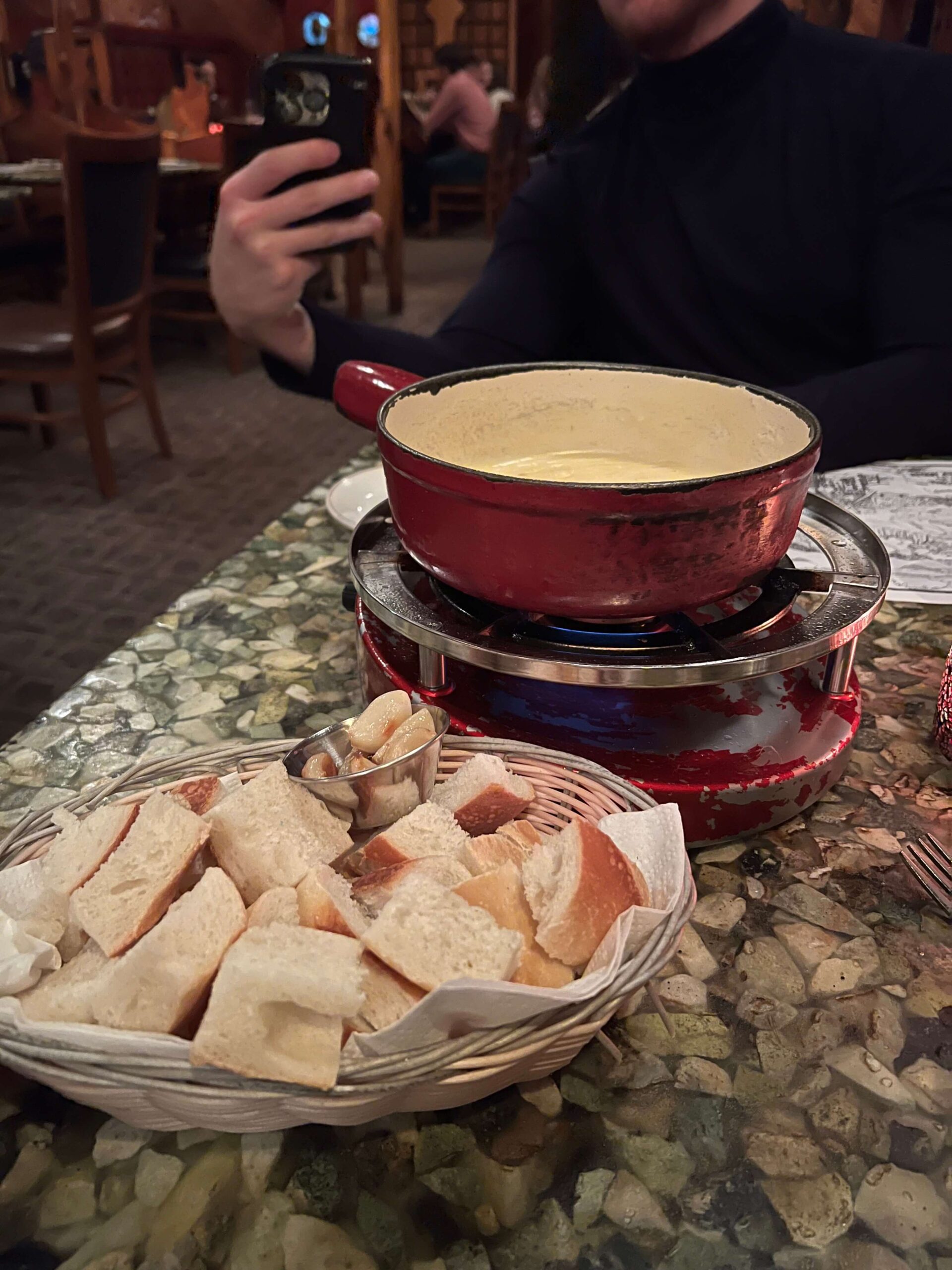 Bread Pieces and a Cheese Fondue in a Red Dish