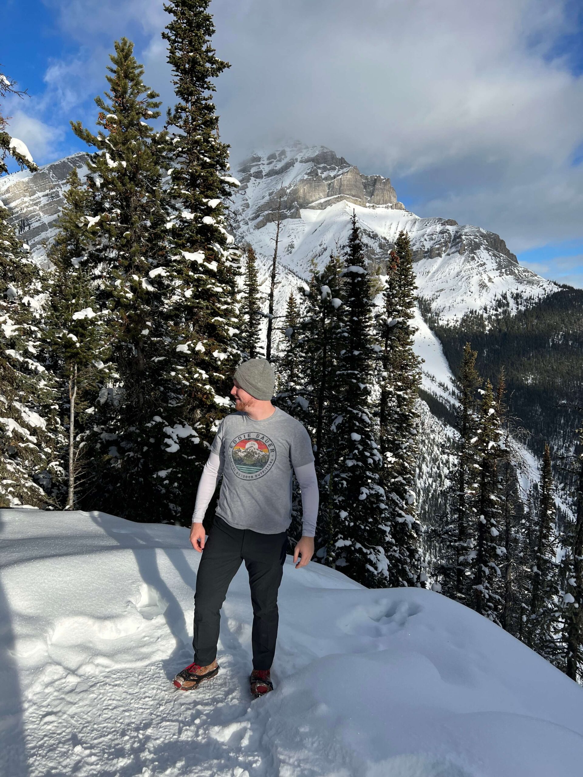 Man Standing in the Snow in front of a Mountain