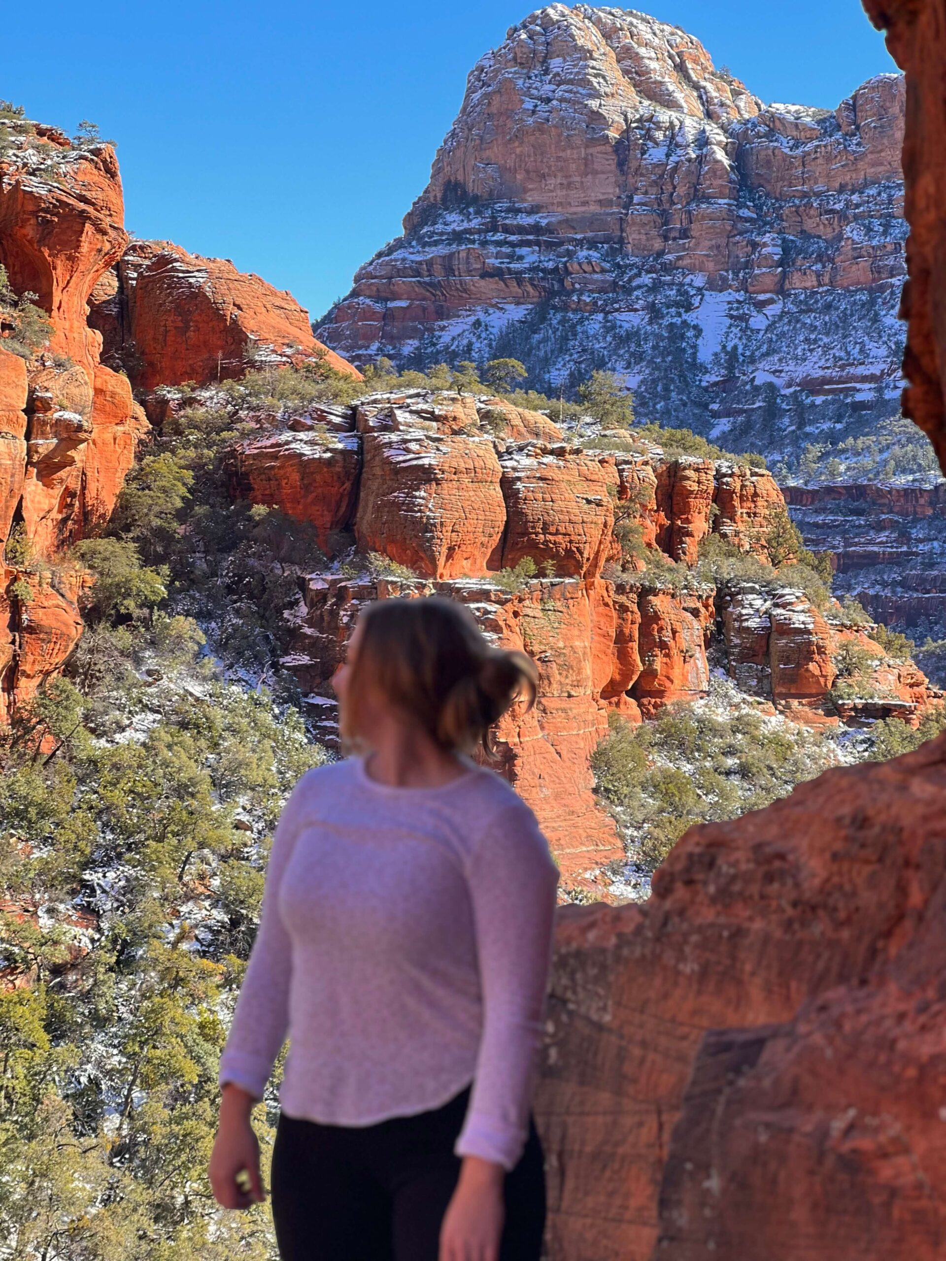 Girl in a White Long Sleeve In Front of Red Rock with Snow