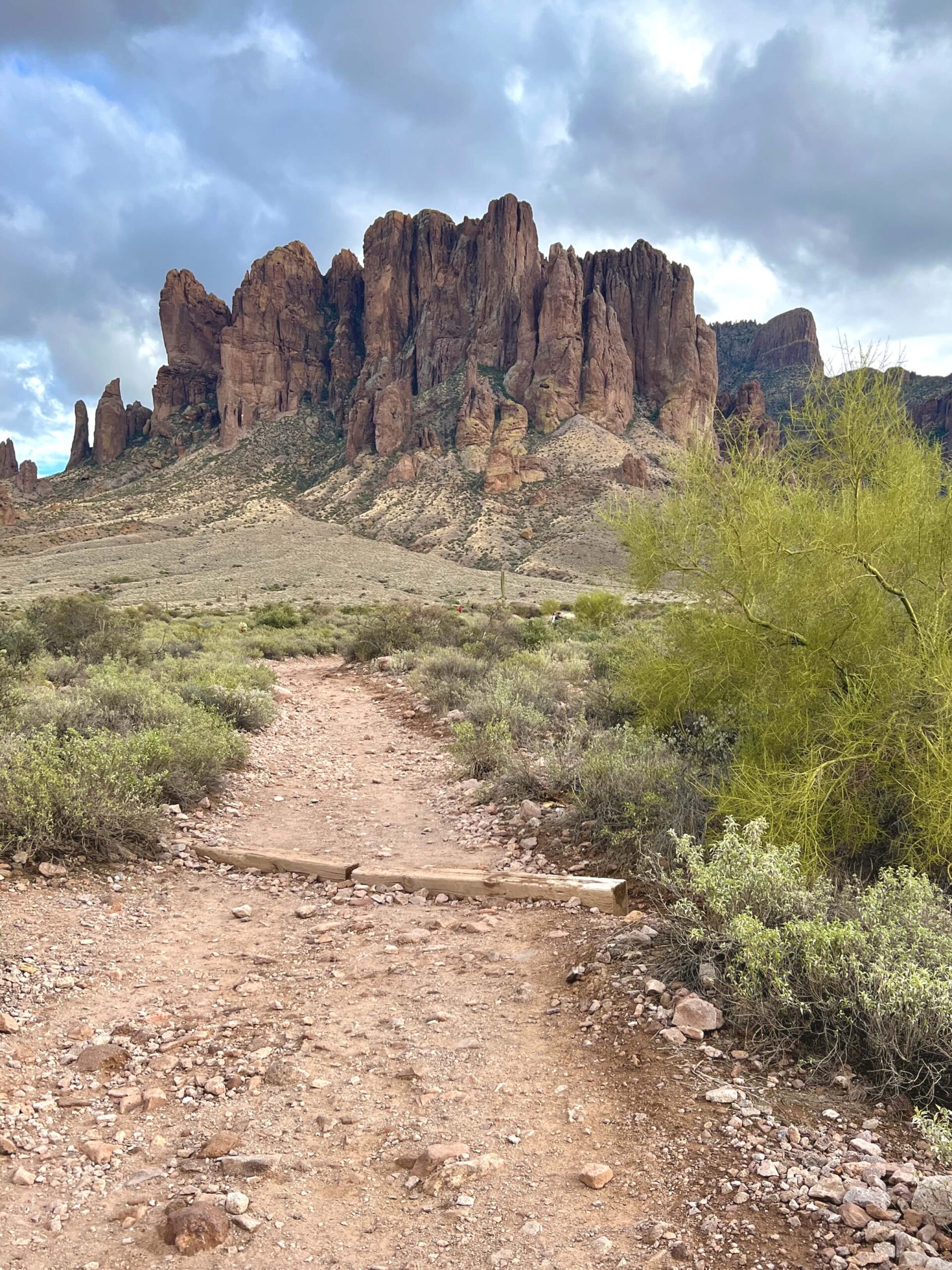 view of tall rugged mountains with a trail leading up to it