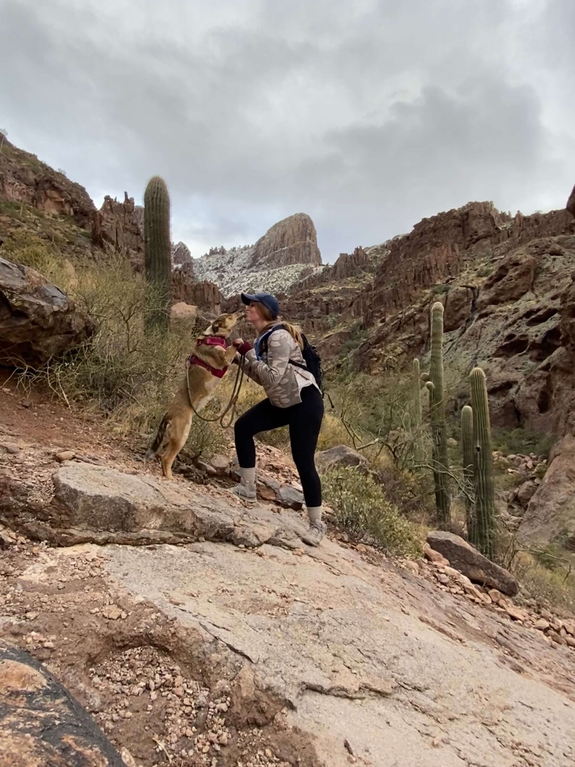 Girl + Dog kissing on a Trail in Winter