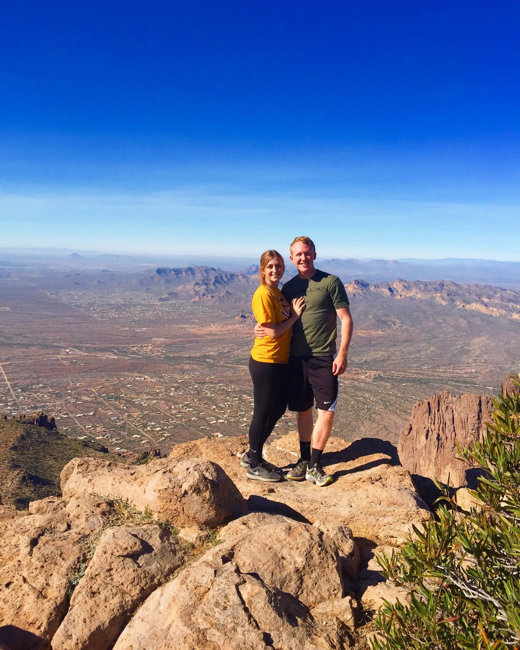 Couple Standing on the top of a tall mountain