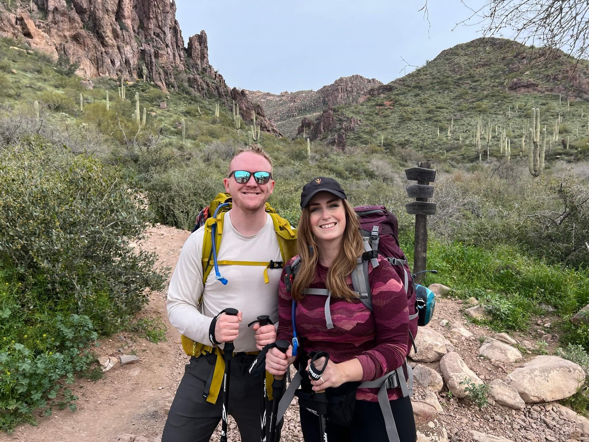 Two People with Backpacking Gear at the Start of a Trail
