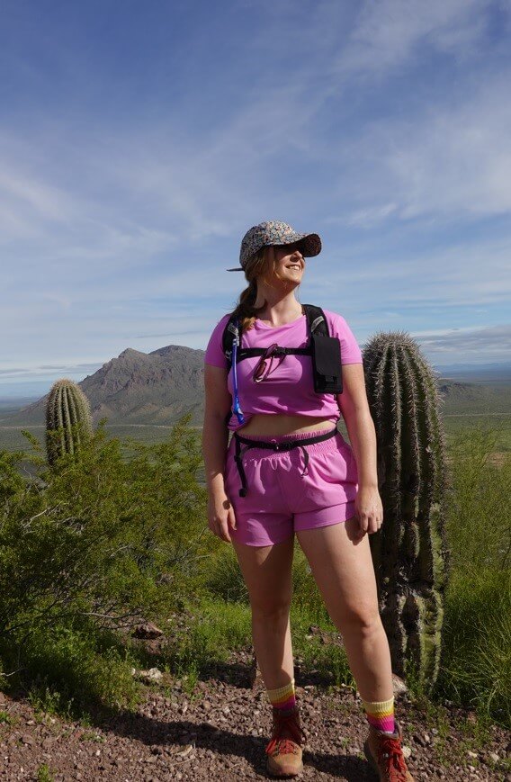 Girl in Pink standing in front of a cactus with a hat on