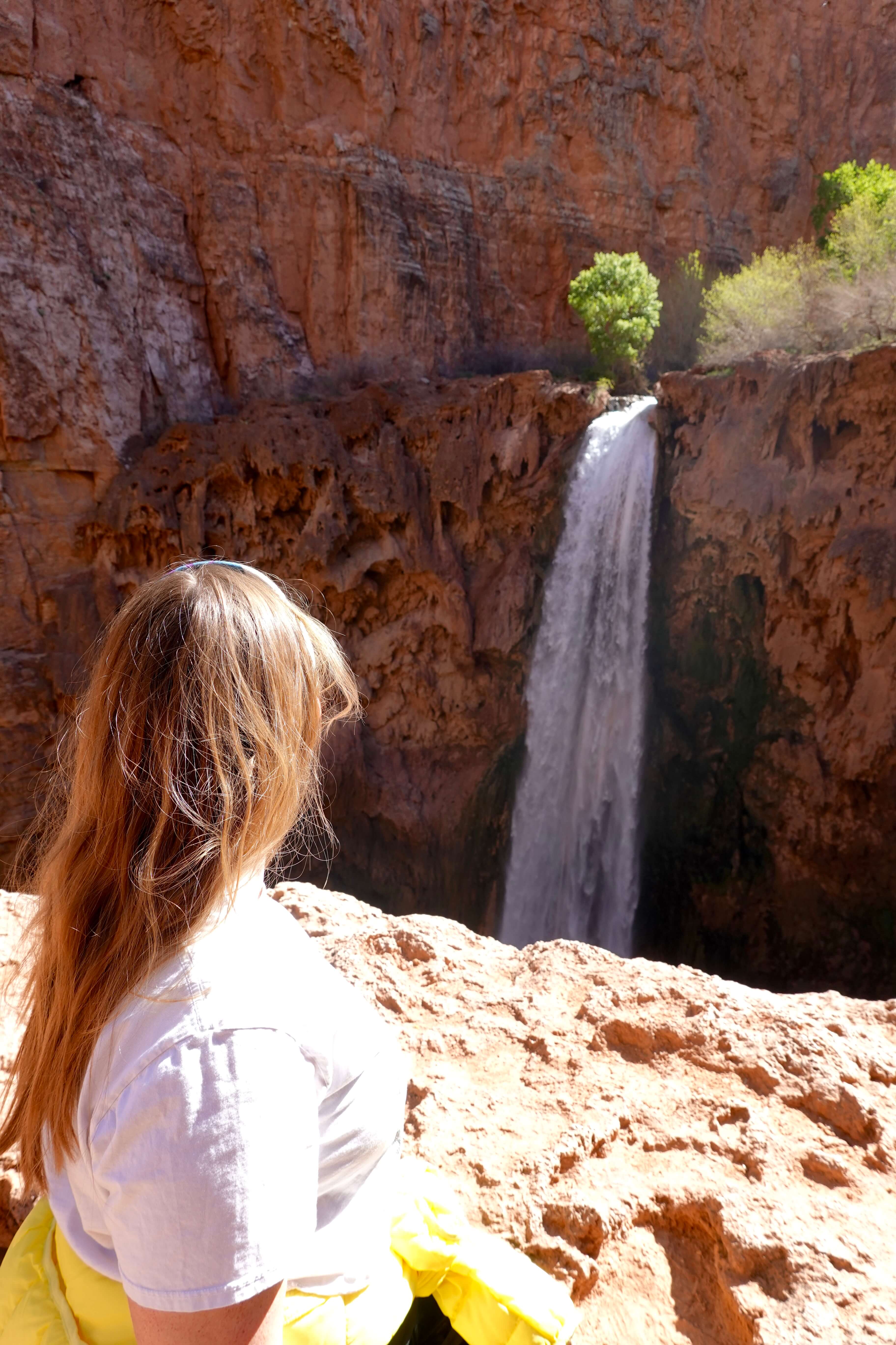 Girl in White Shirt and Yellow Jacket at the Top of Mooney Falls