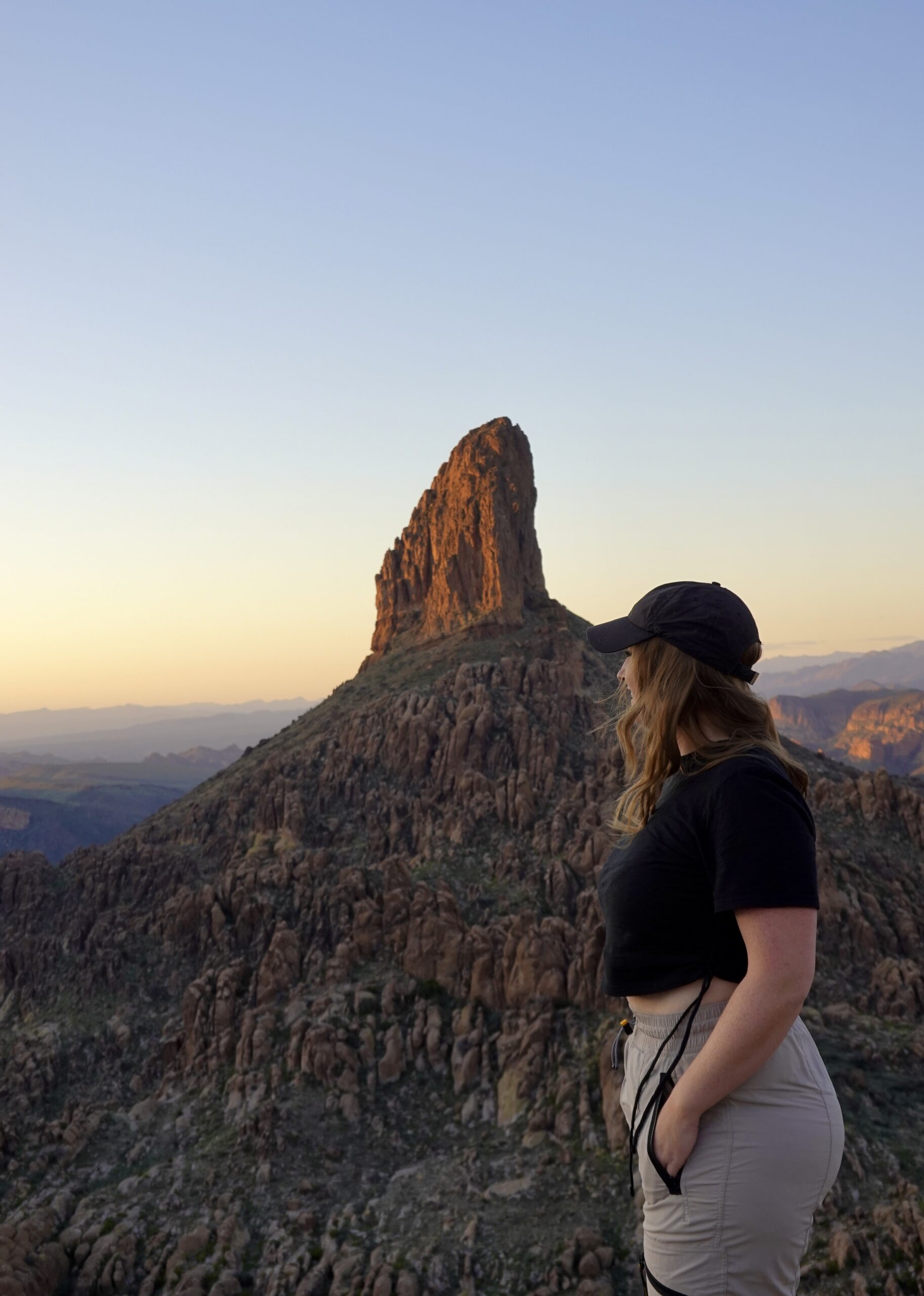Girl Standing Next To Weavers Needle at Sunset