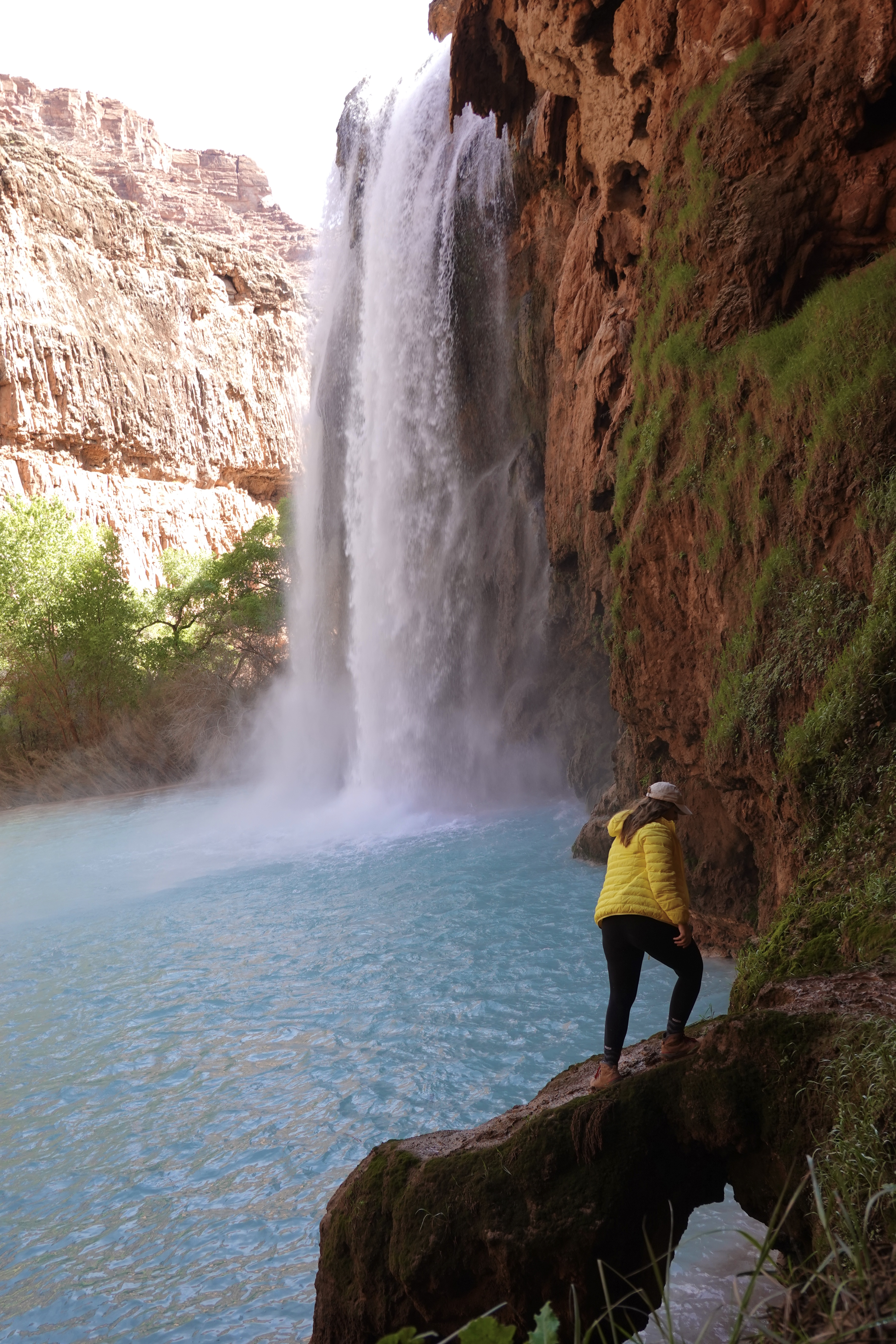 Girl Standing on a Ledge in Front of a Waterfall