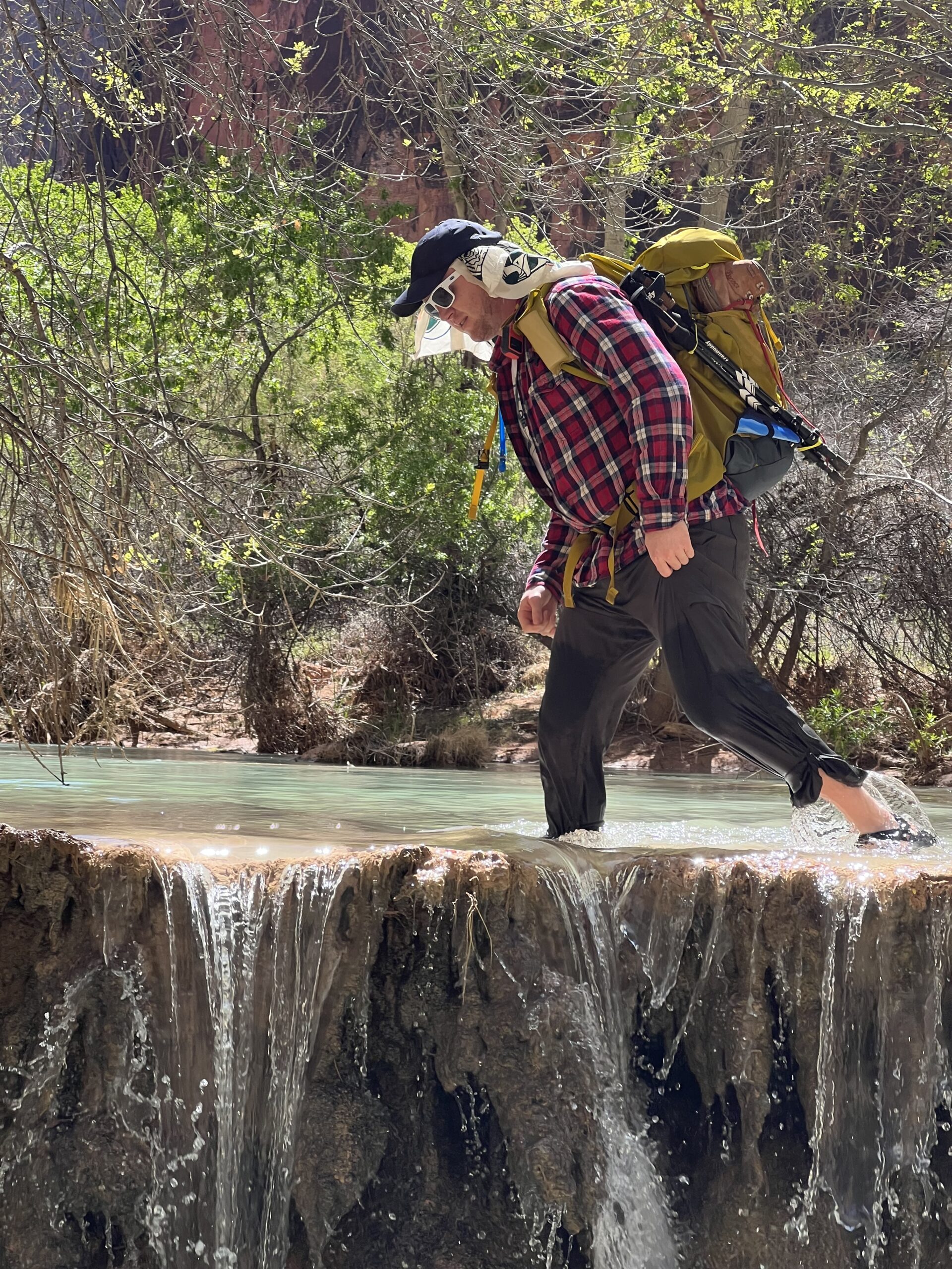 Man in Long Sleeve Walking Through a Creek