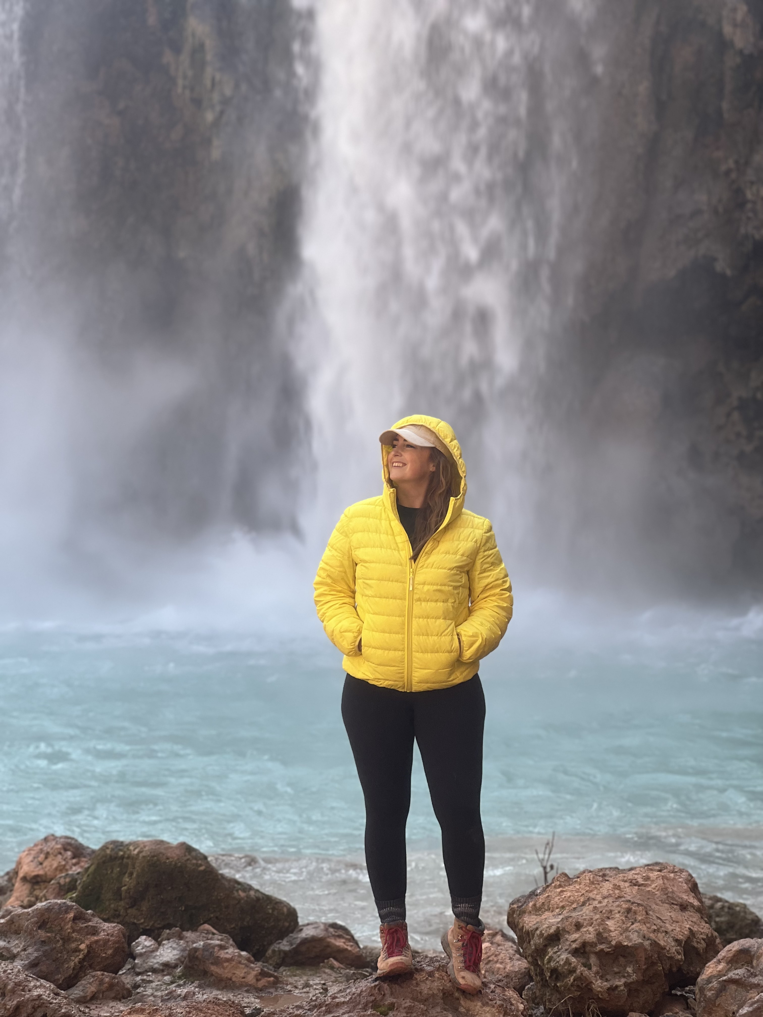 Girl in a Yellow Coat in front of Waterfall