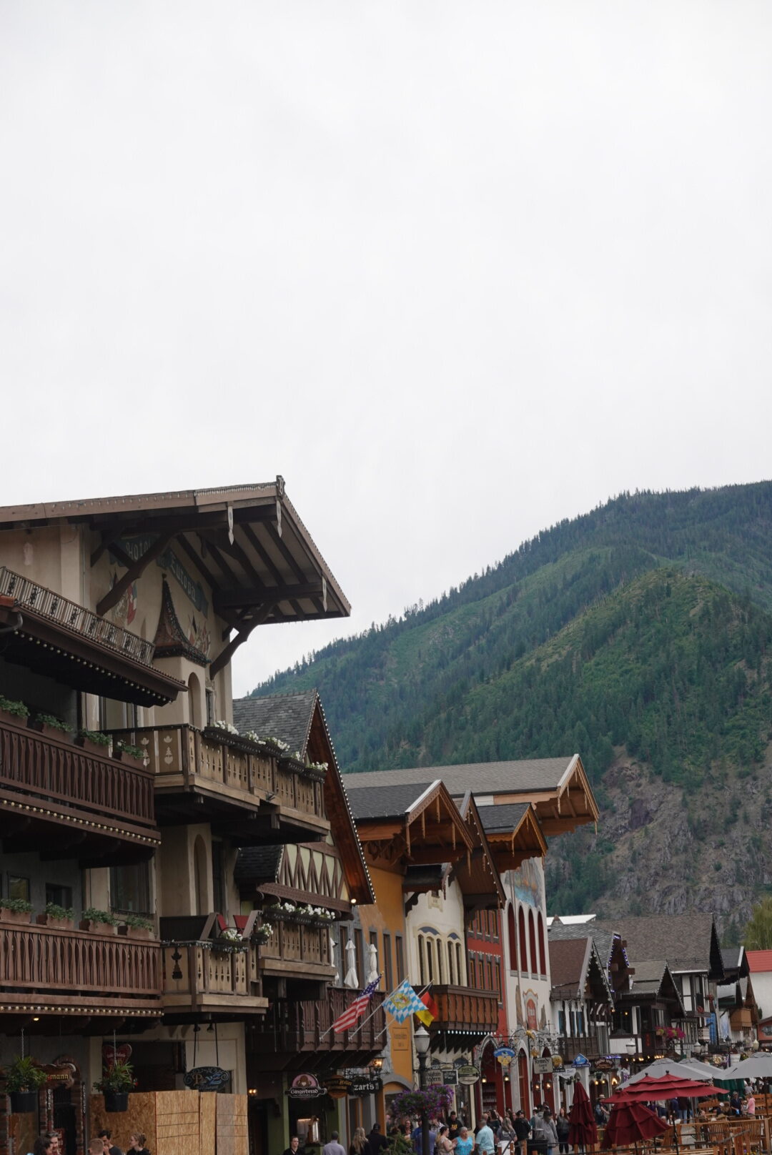 Multiple Pointed Buildings with a Bavarian Theme in front of a mountain range