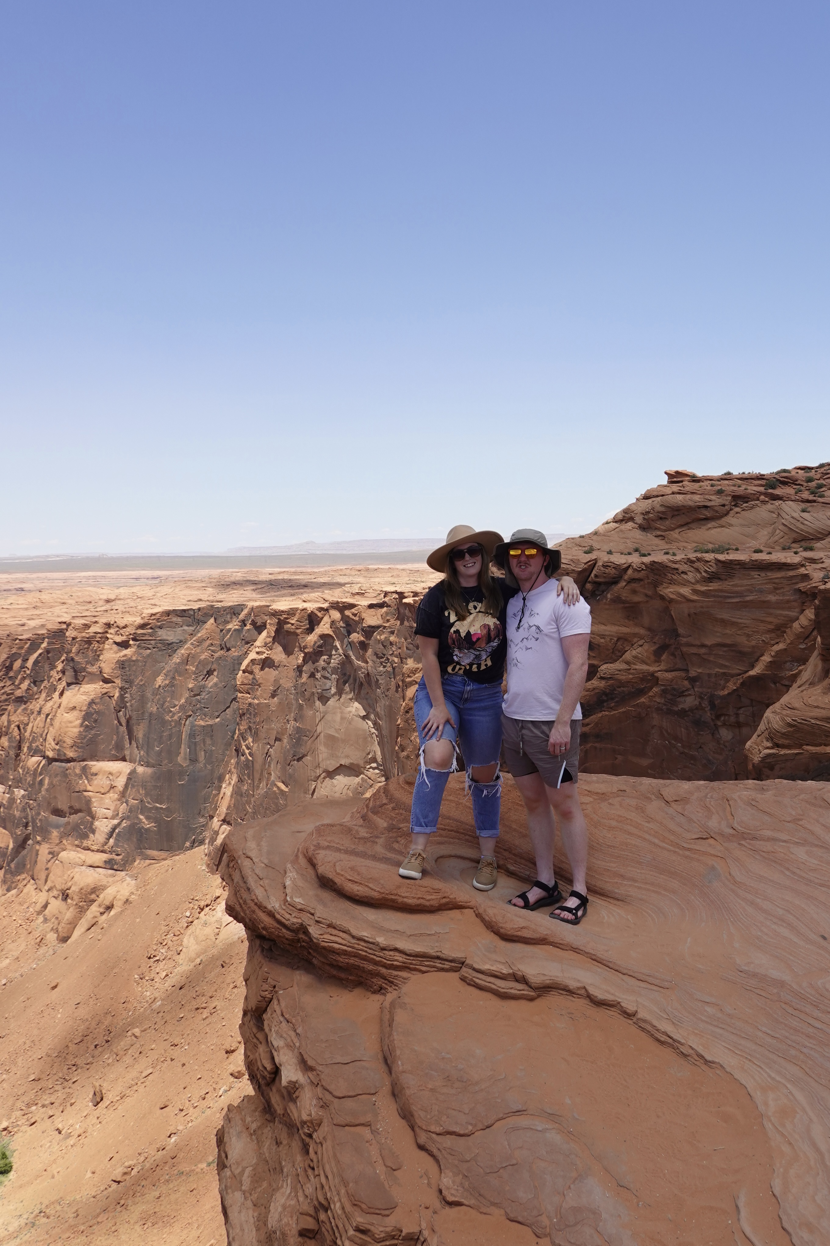 Two People Standing Next to Each Other on a Cliff