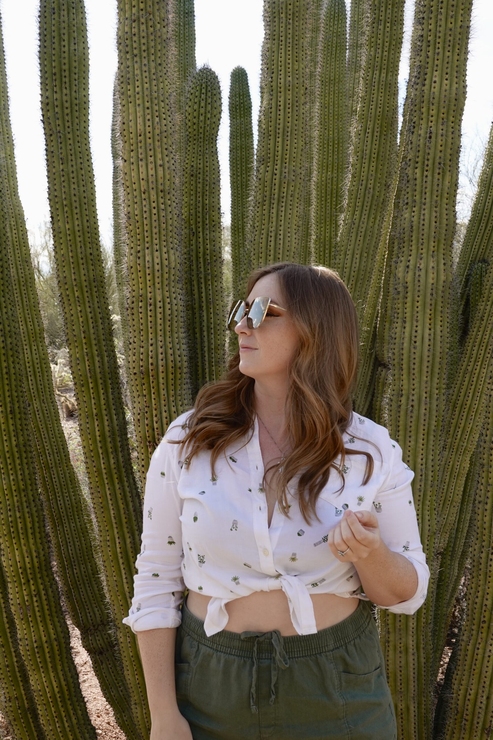 girl in a white shirt and sunglasses in front of cactus