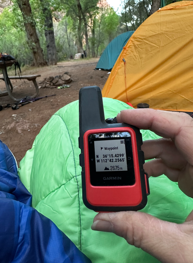 person holding a garmin near a tent