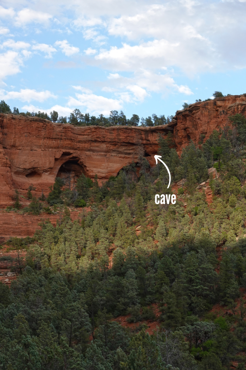 distant view of a cave in the red rock walls