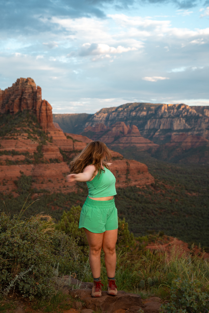 girl in green outfit with her hands raised in sedona