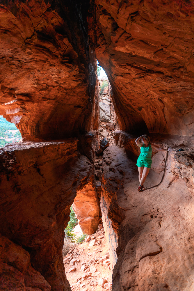 girl in green standing in a cave