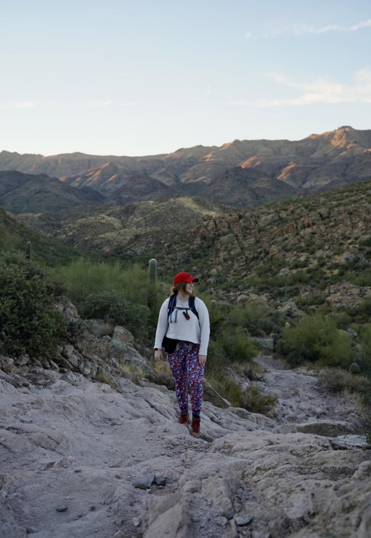 girl in white shirt and red hat in the mountains