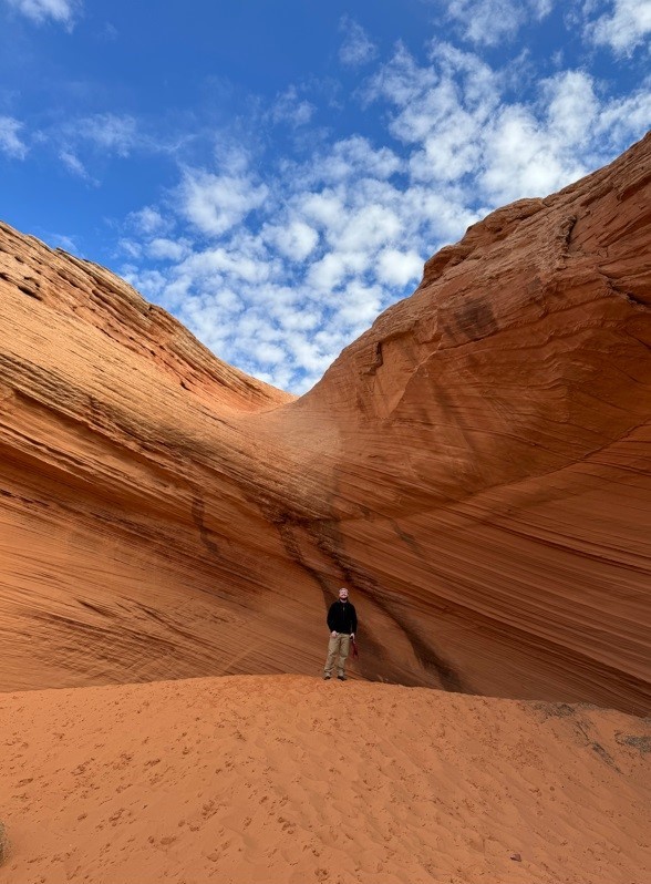 man up against red rock with a blue sky