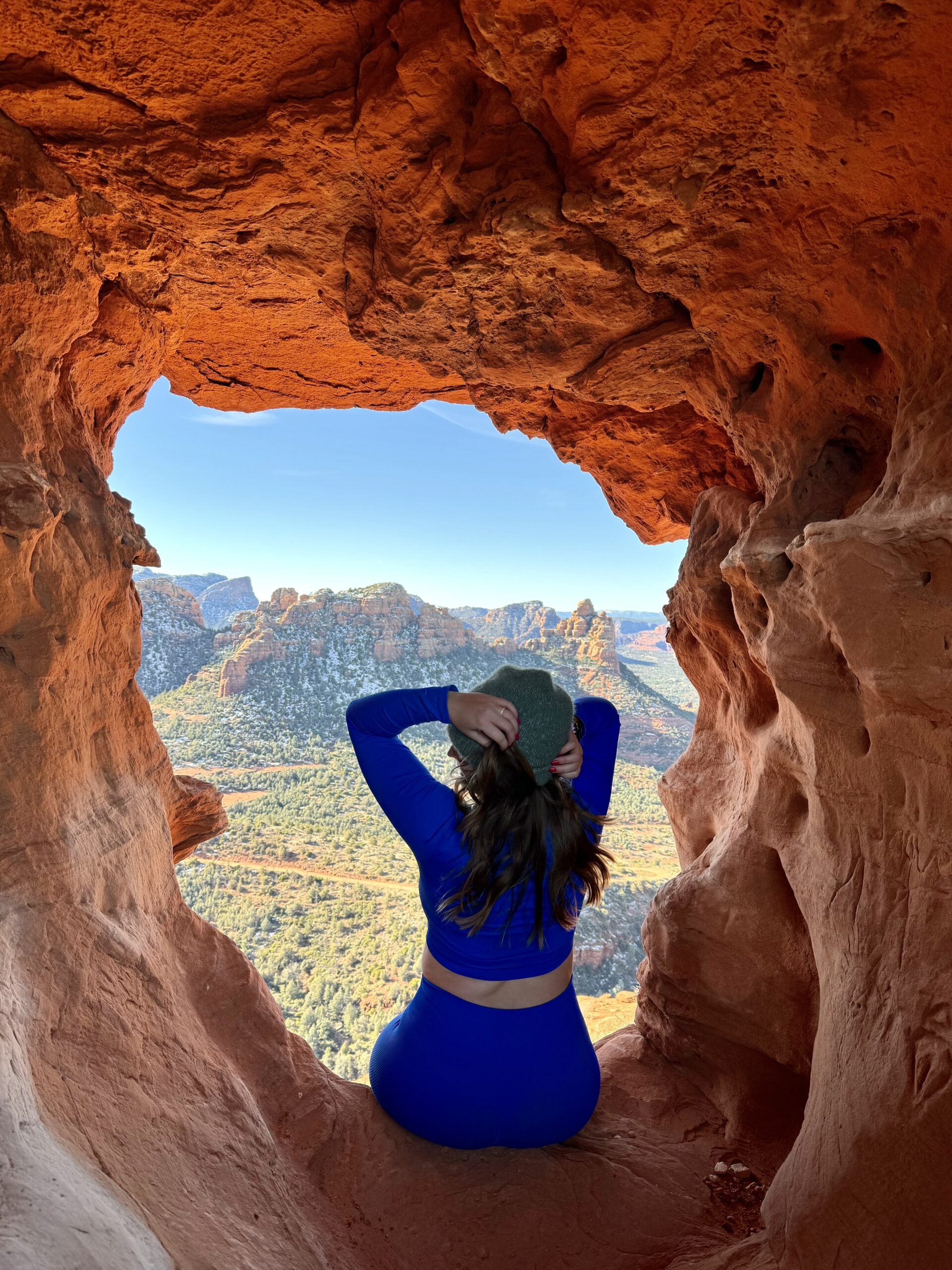 girl in blue outfit sitting in a cave in sedona