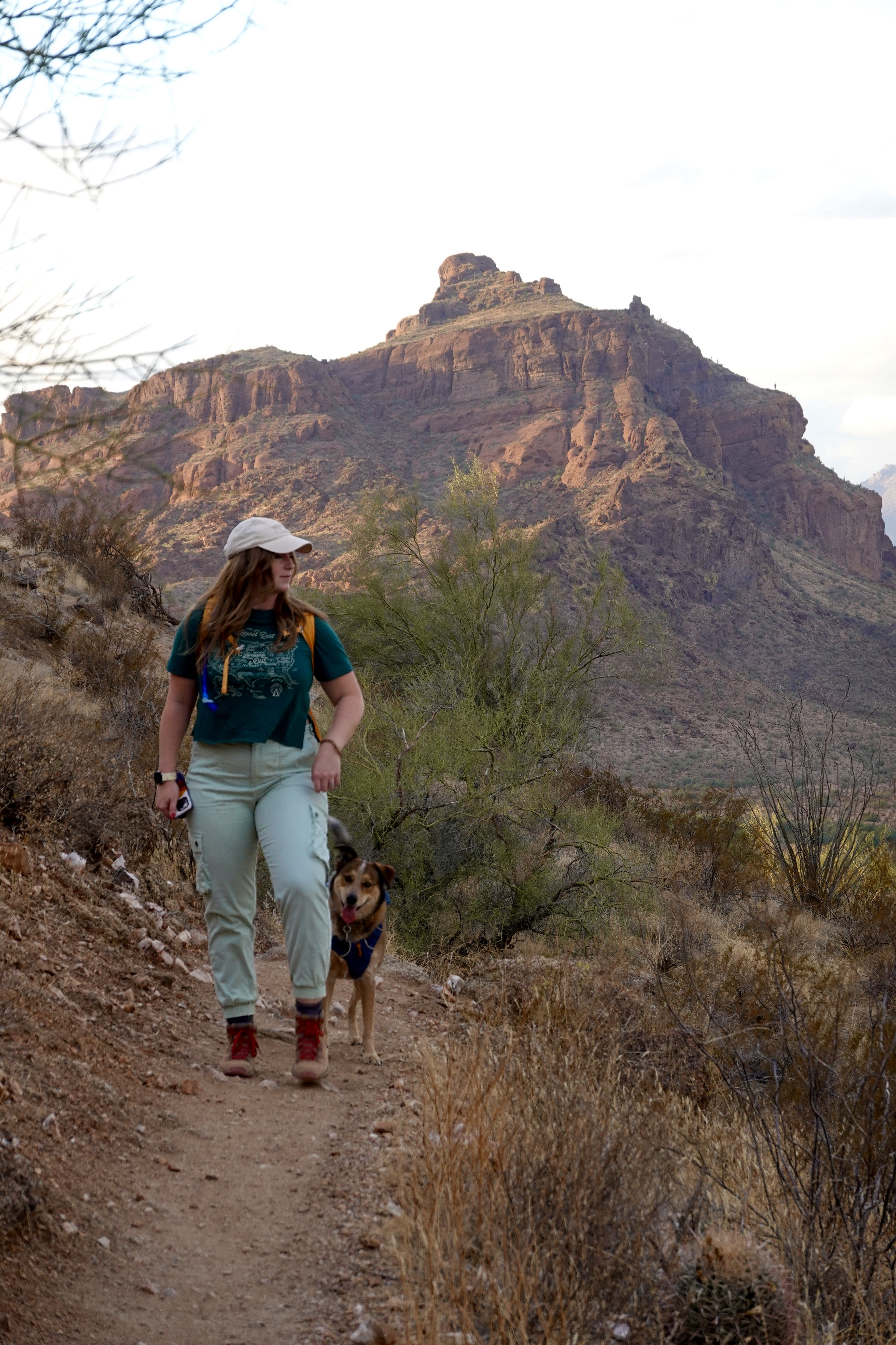 girl wearing green hiking with a dog