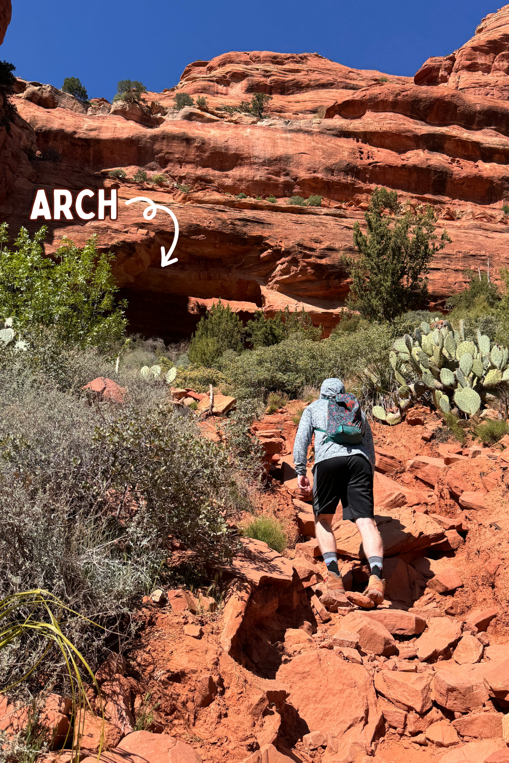man hiking up to fay canyon arch