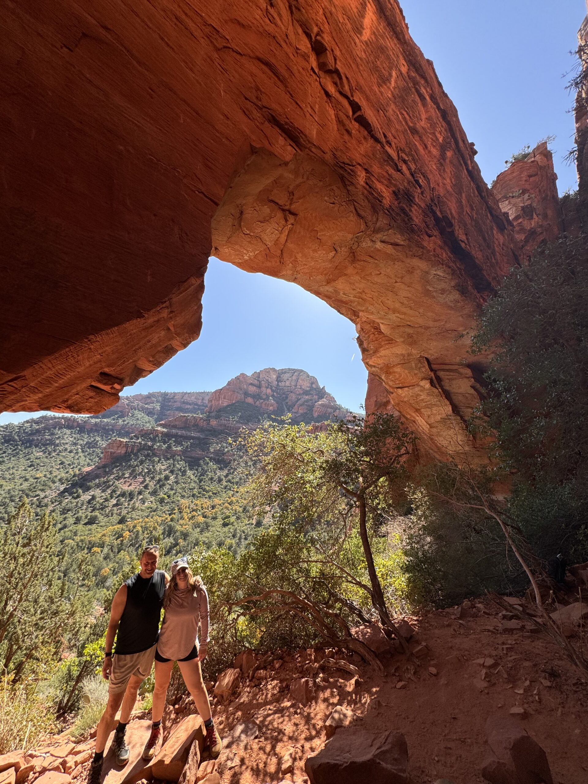 two people under fay canyon arch in sedona
