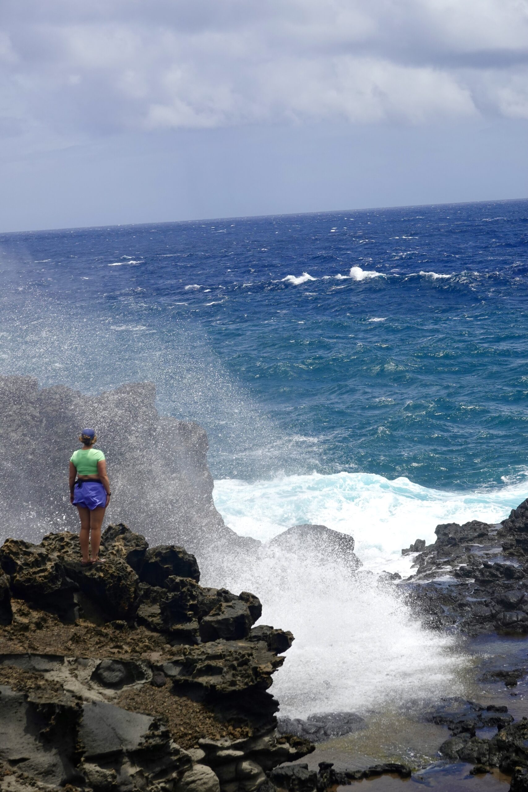 girl standing by a blowhole in maui hawaii