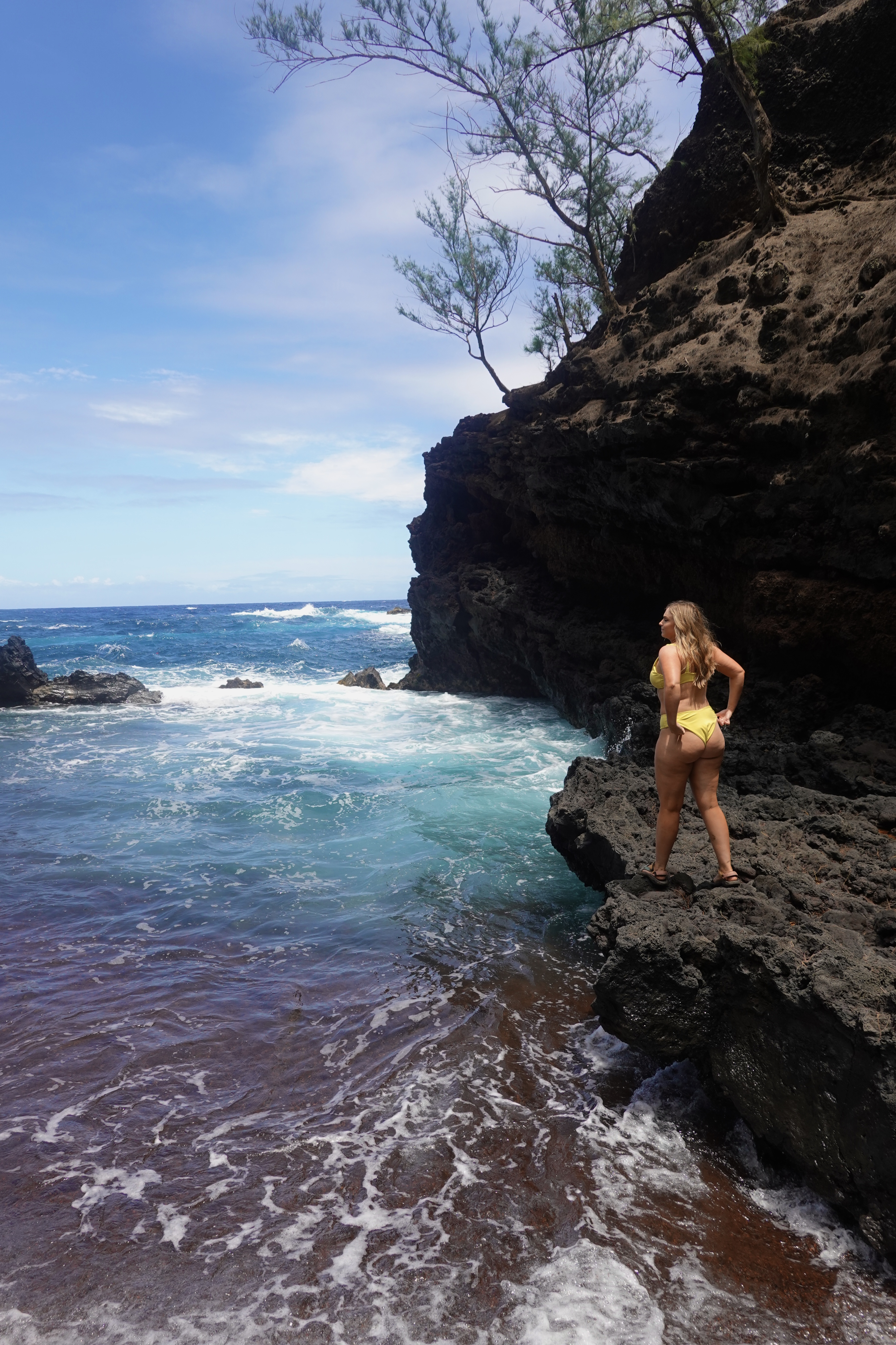 girl in yellow bikini at red sand beach