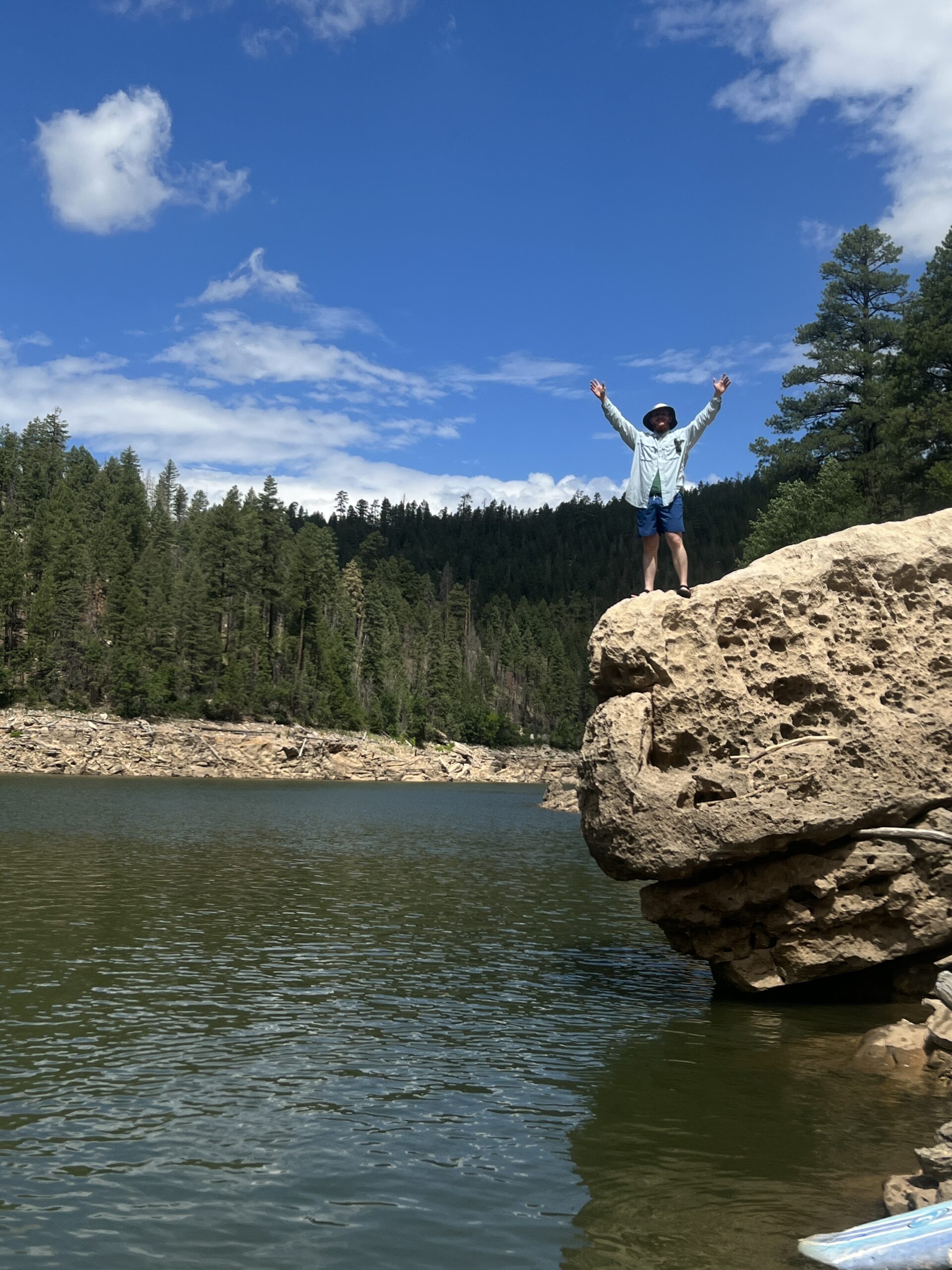 man standing on a cliff over water