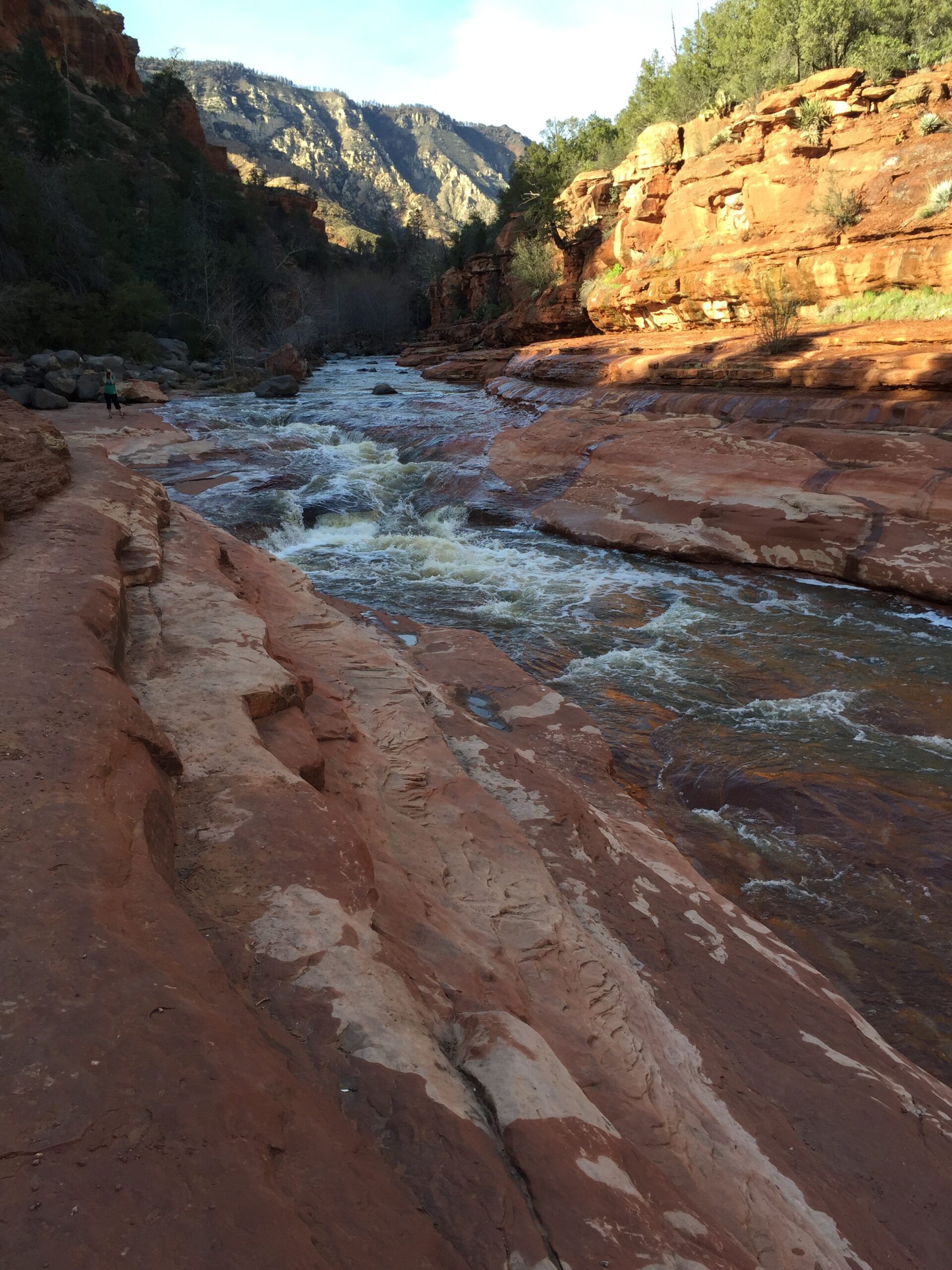 slide rock state park in sedona water rushing over red rock in a canyon at sunset