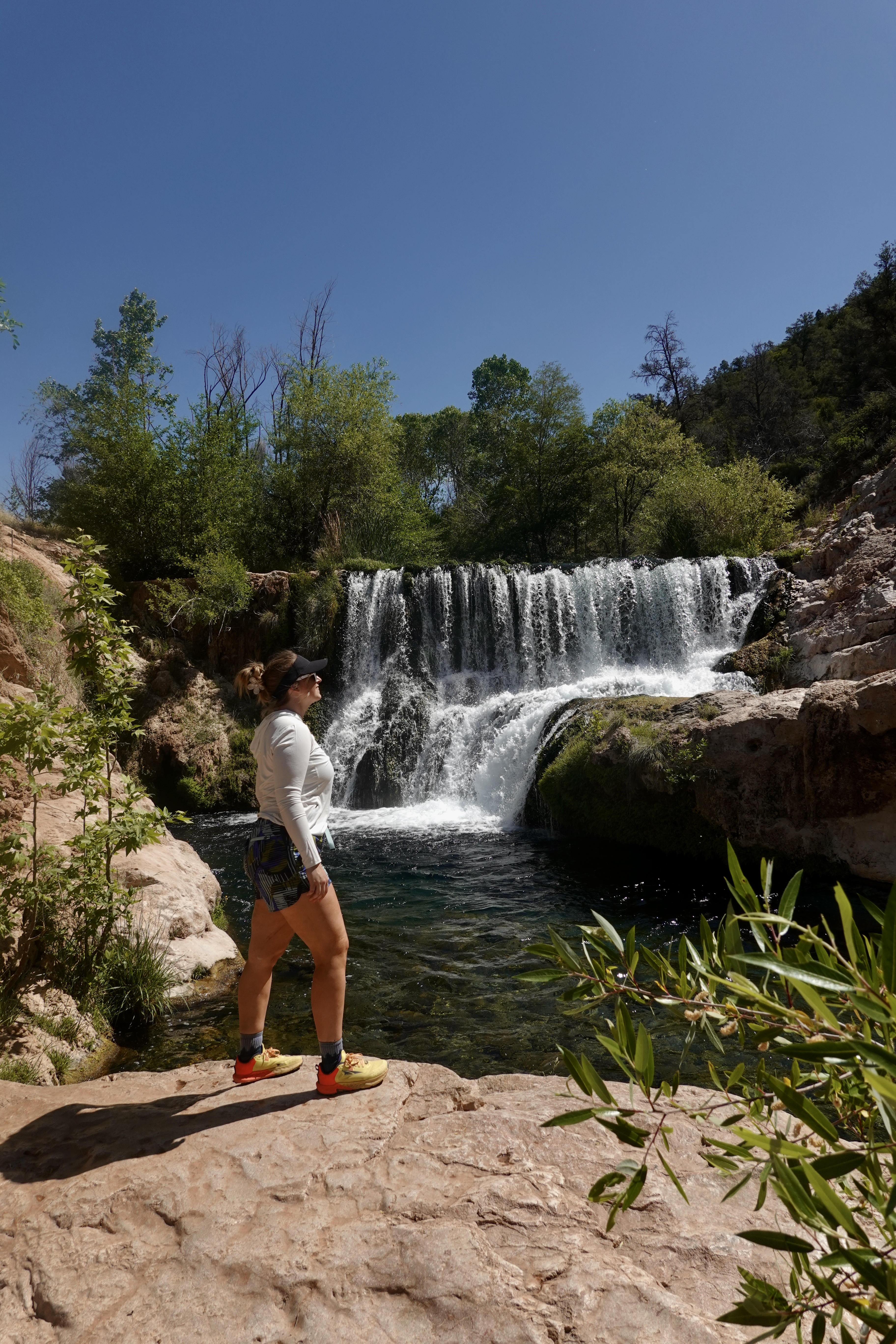 girl standing in front of a waterfall