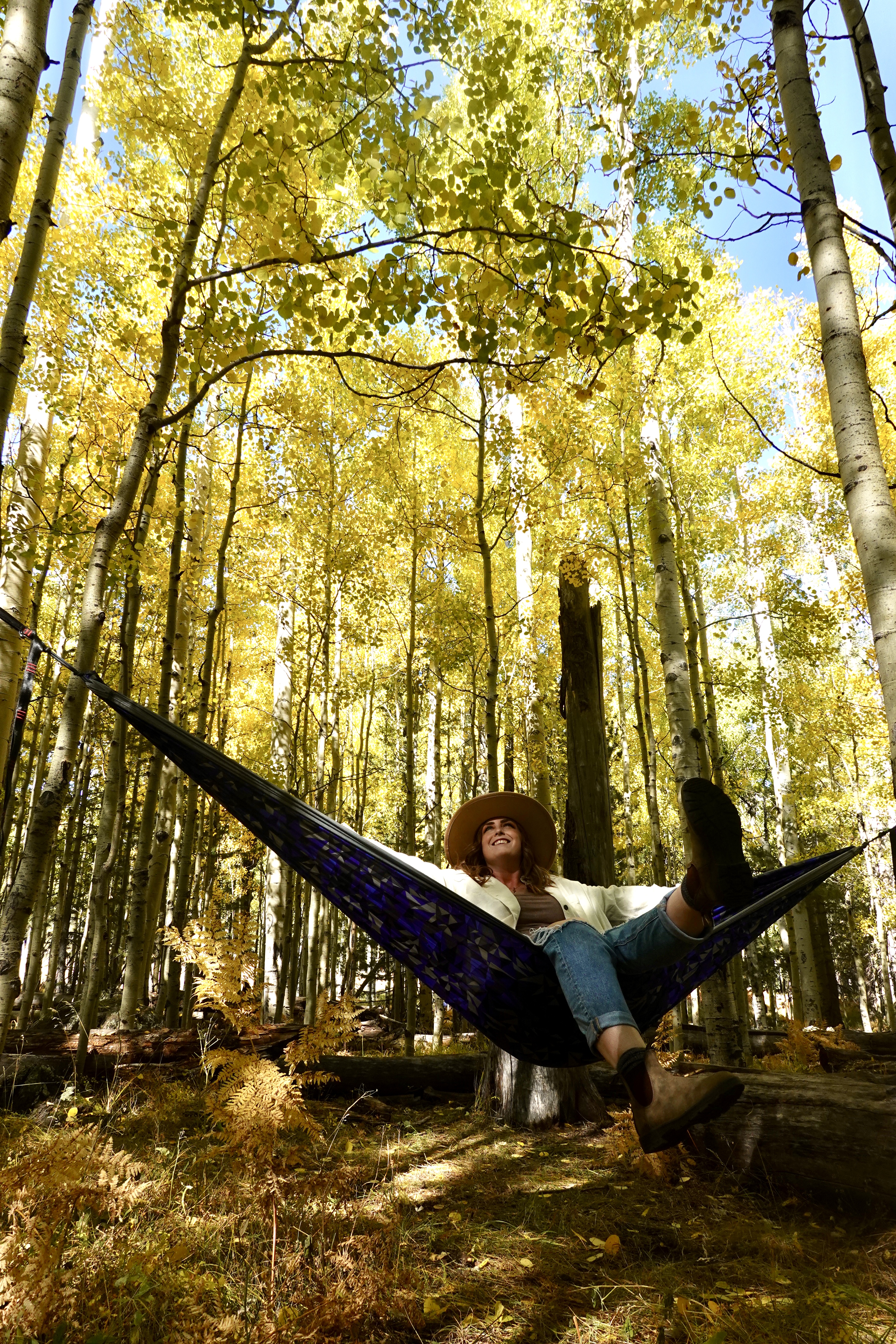 girl sitting on a hammock in the yellow trees