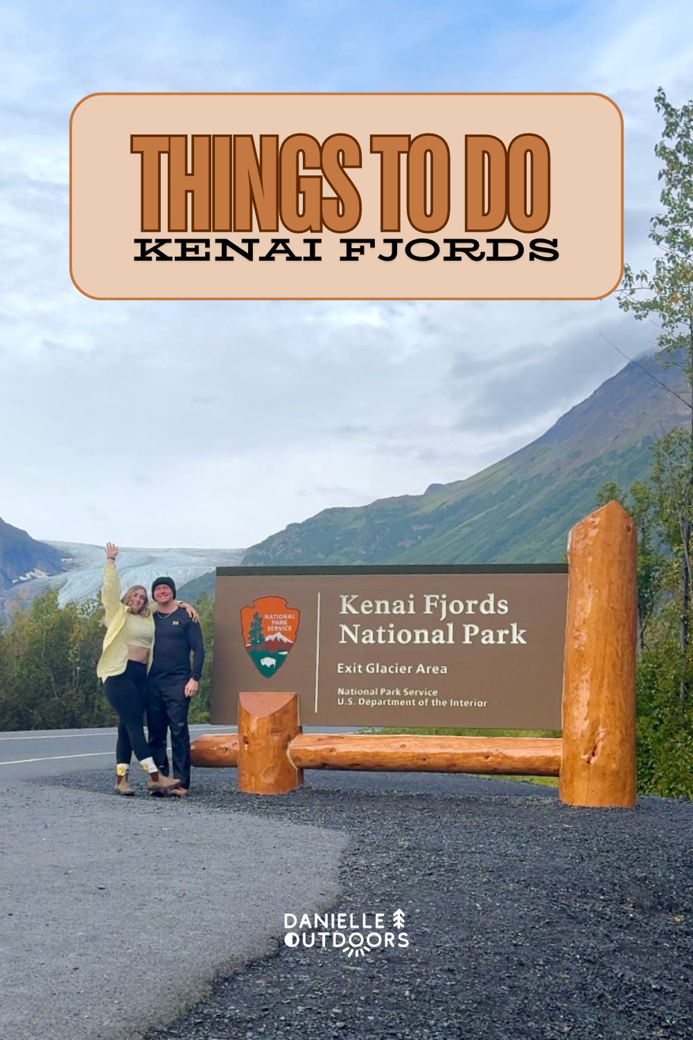 two people standing b a national park sign