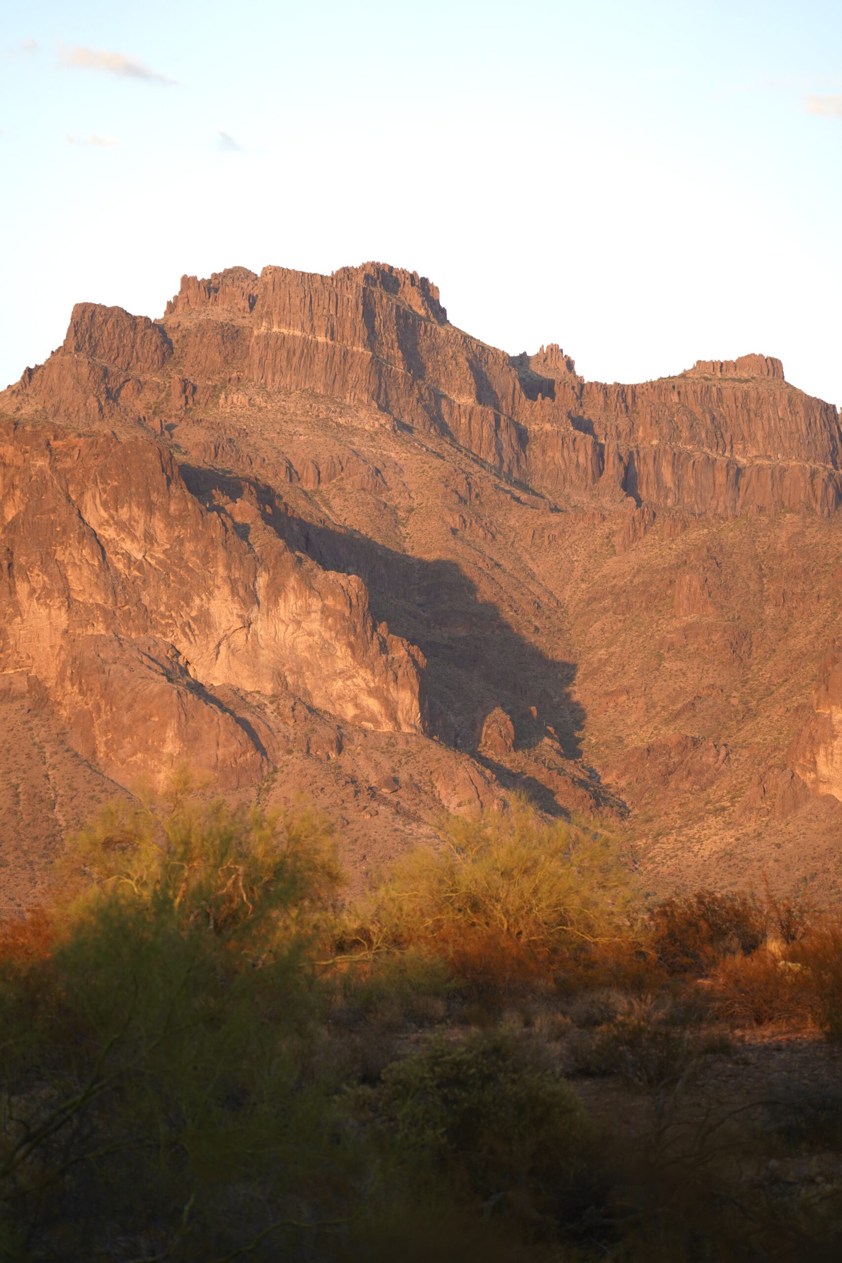 photo of a shadow on a rugged mountain at golden hour