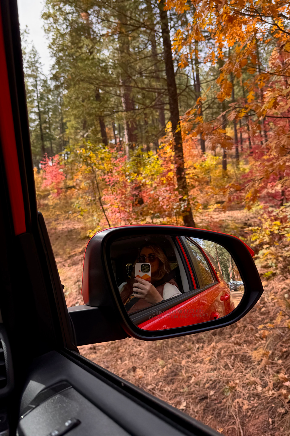 girl driving to a trail in the fall colors