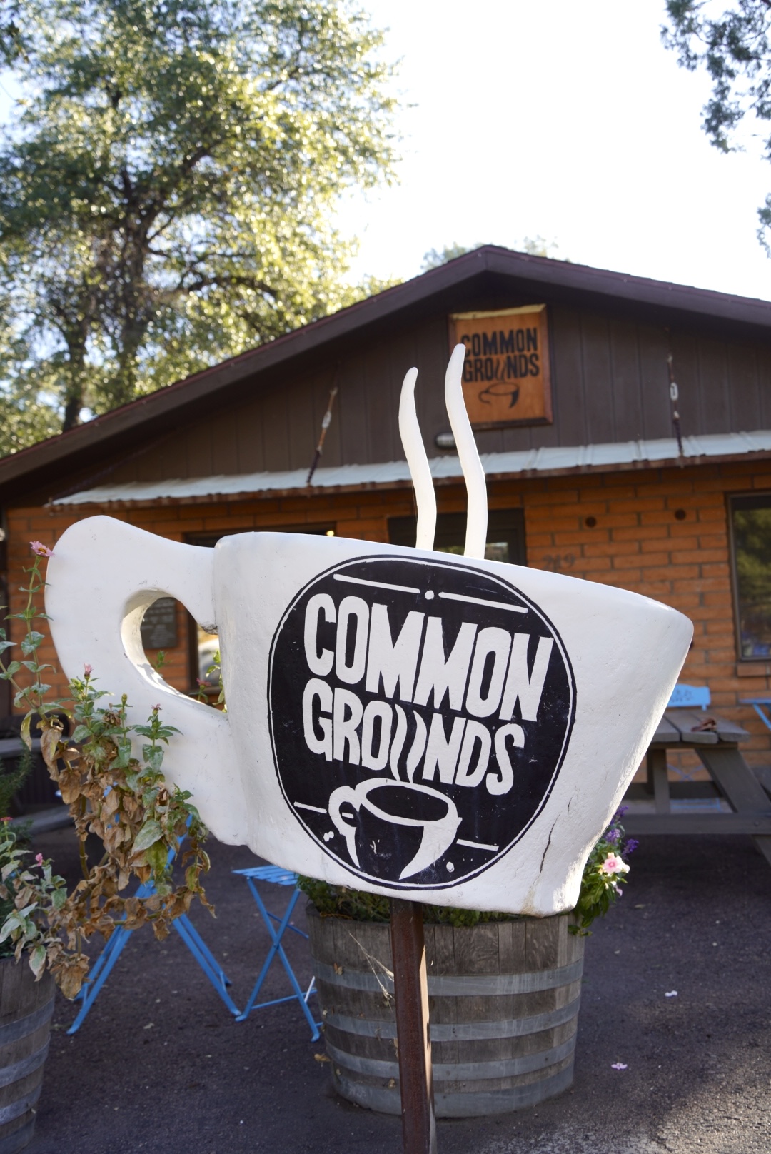 Photo of a coffee mug in front of a building with a logo on it