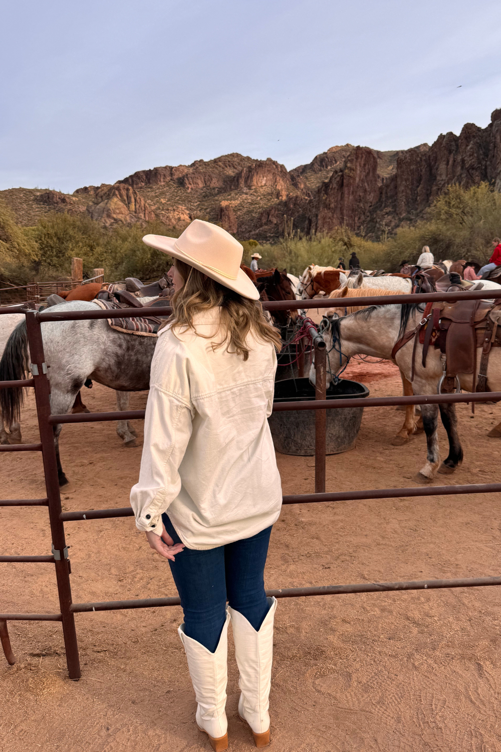 photo of a girl standing in front of a horse ranch