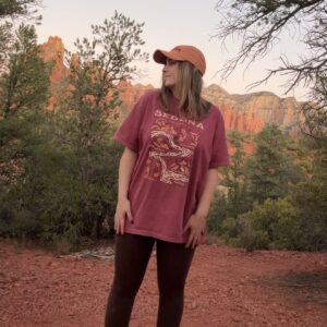 Person in hiking gear standing in a red rock landscape in Sedona, Arizona.