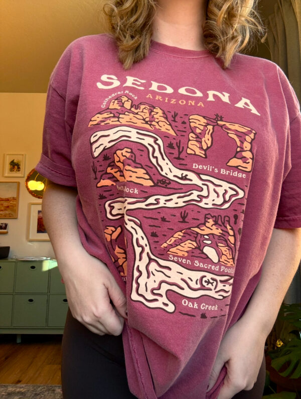 girl wearing a maroon colored tshirt that says sedona with landmarks on it